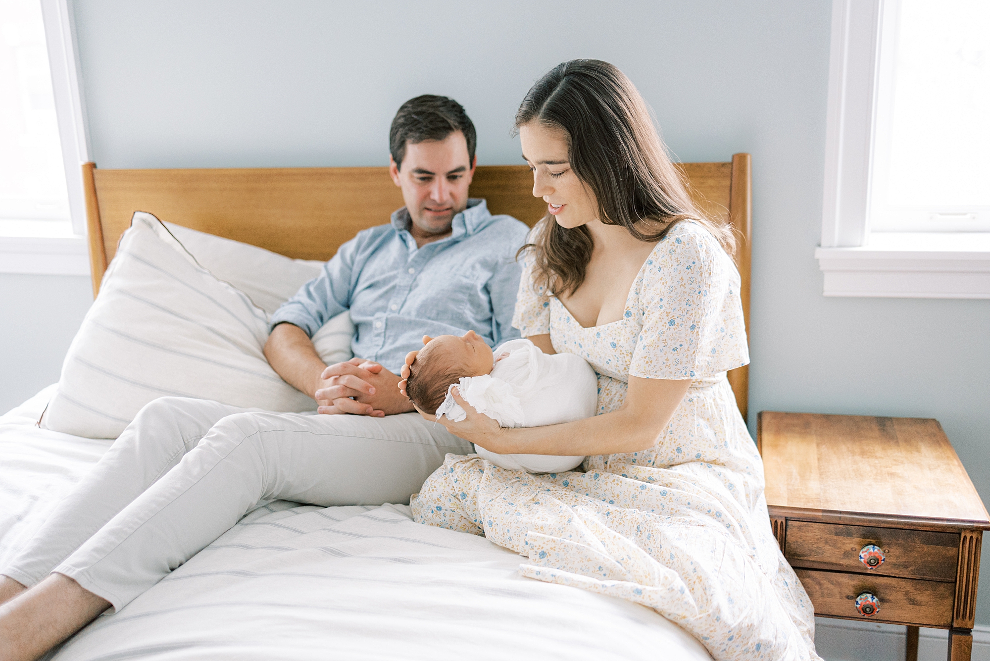 new parents talk looking at son sitting on bed