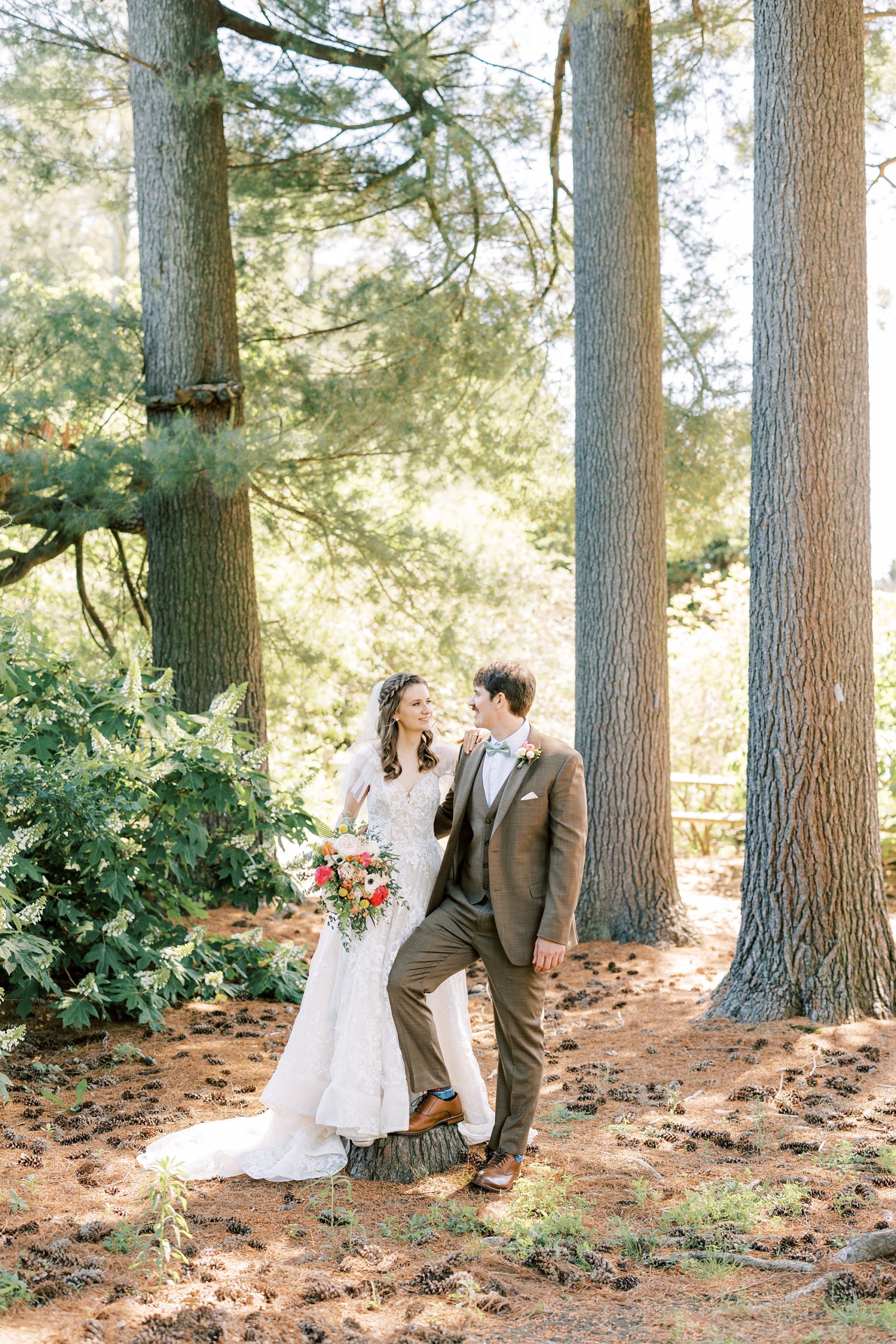 newlyweds walk through woods at Tyler Arboretum