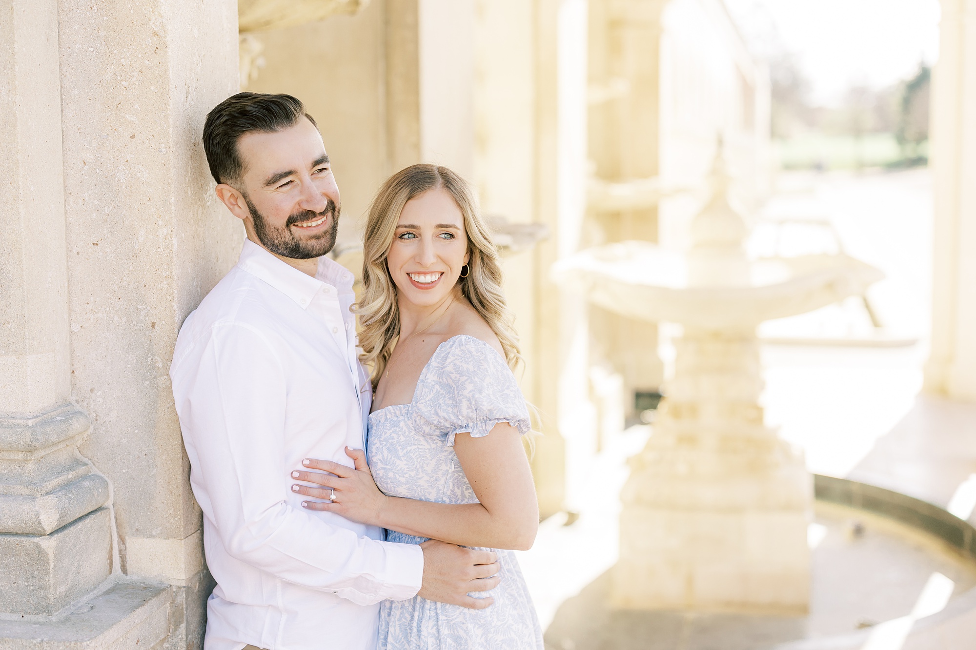engaged couple smile near fountain at Longwood Gardens
