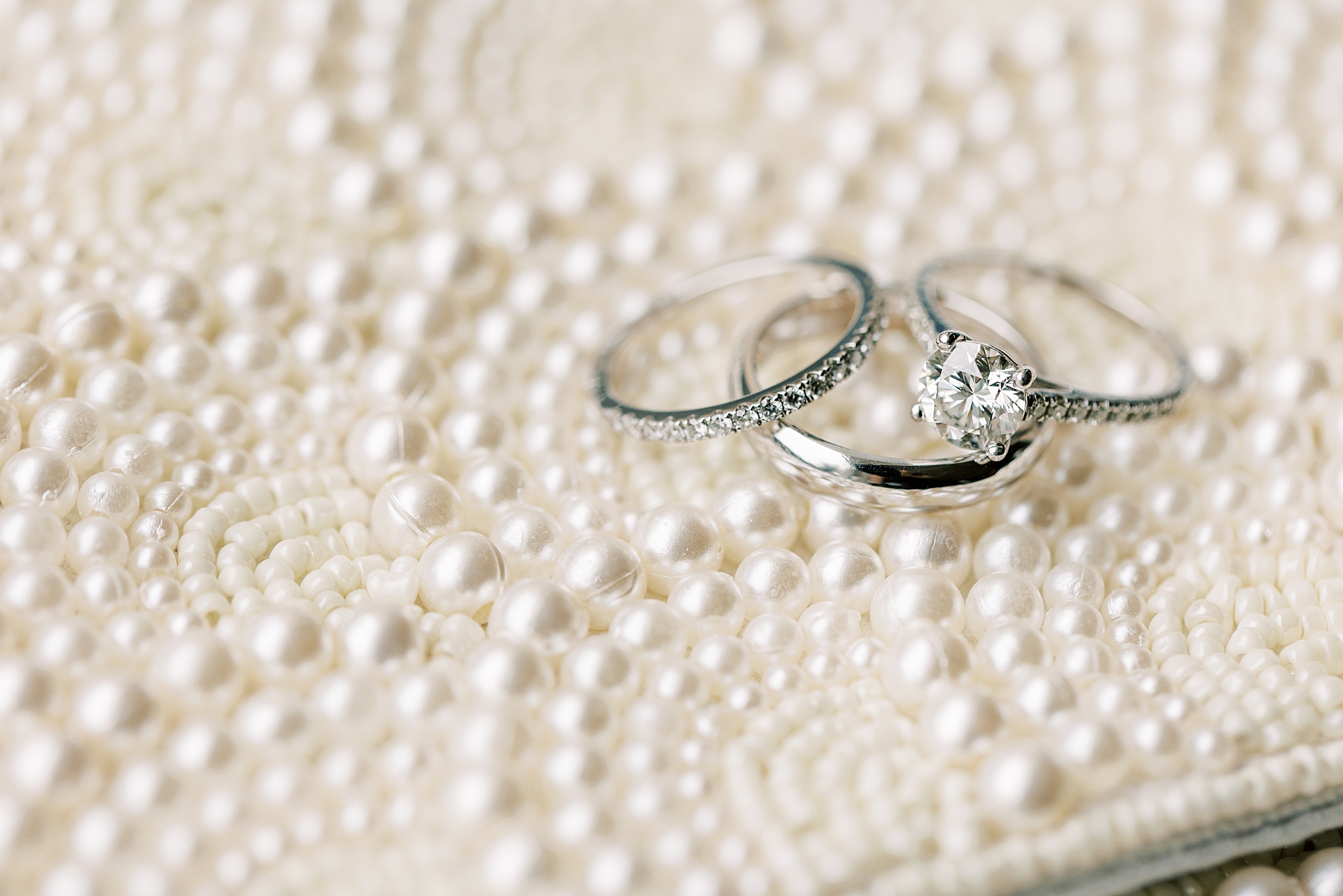 wedding bands lay on pearl detailed mat