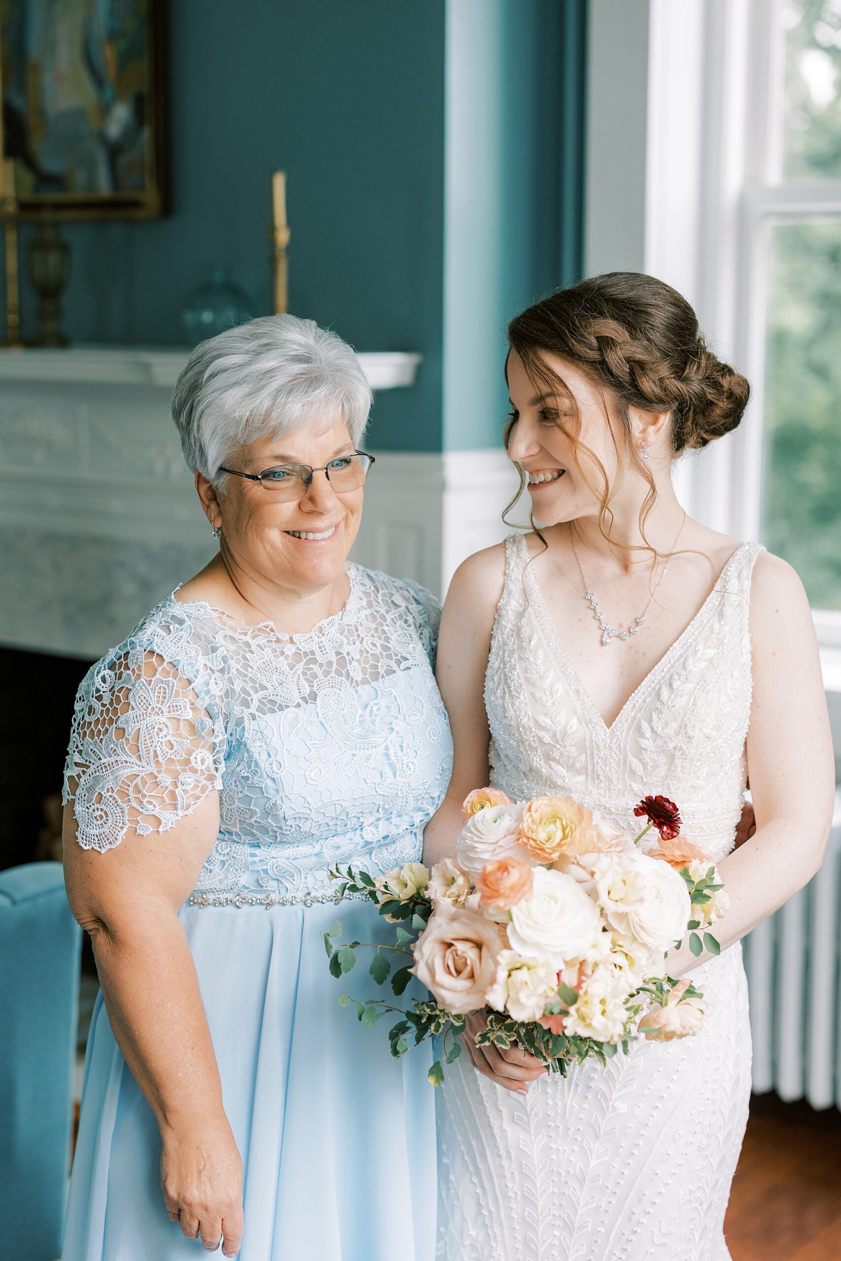 bride smiles at mother during prep on wedding day at Bellevue Hall