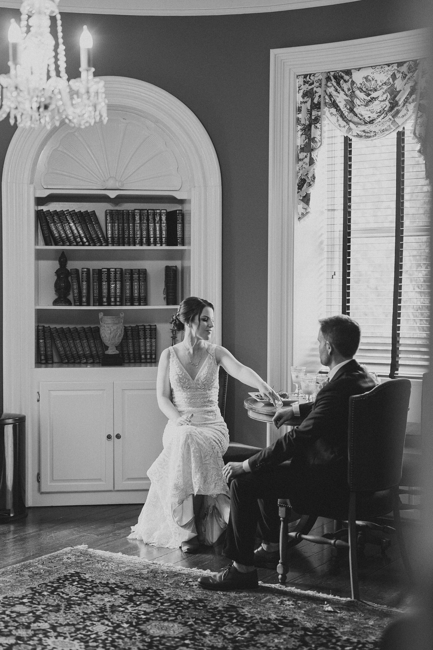 bride and groom sit in library at Bellevue Hall