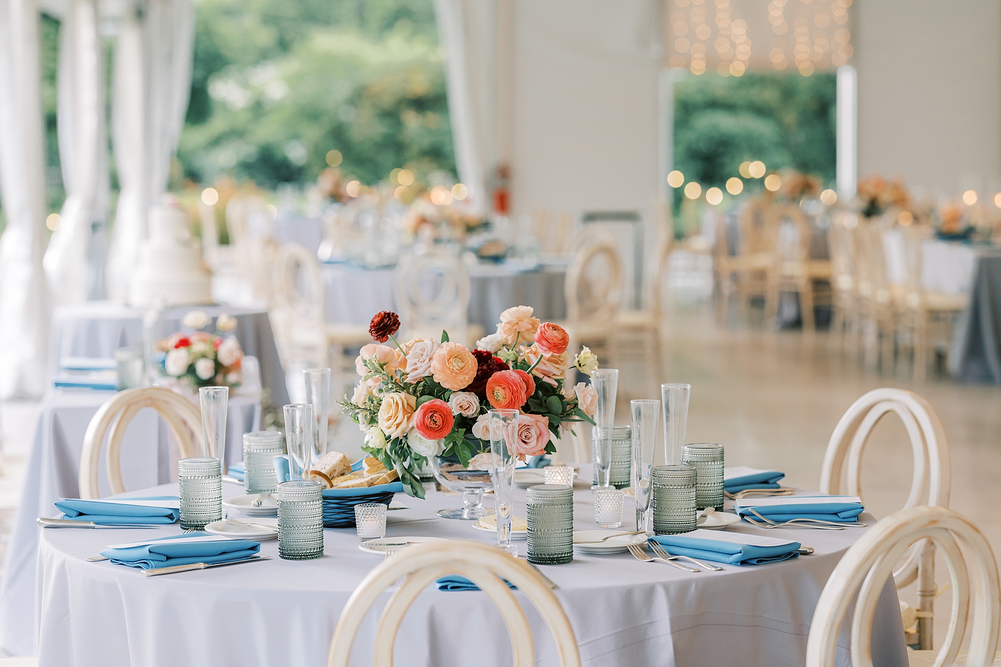 reception tables with blue table clothes and pink flowers