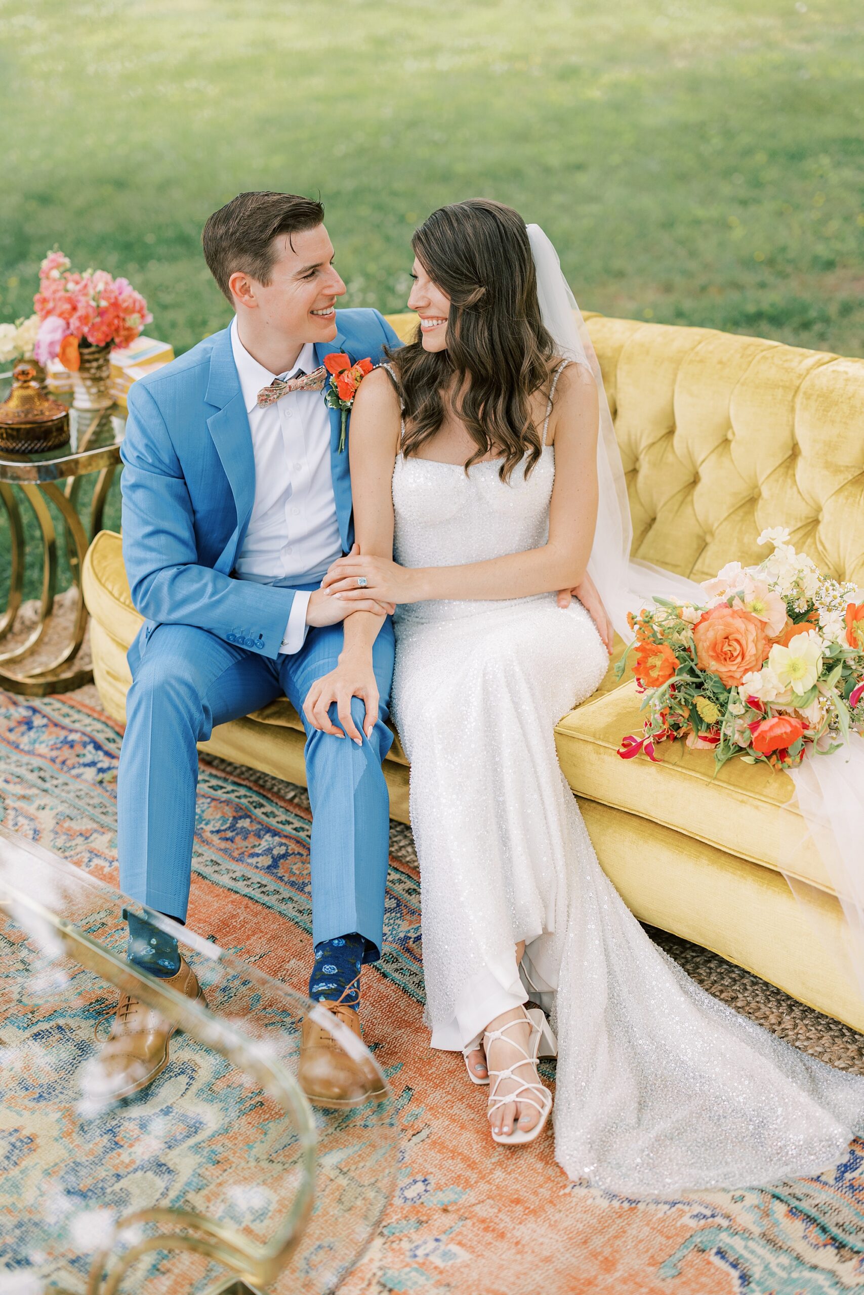 bride and groom sit on yellow sofa during reception at Bowman's Hill Wildflower Preserve