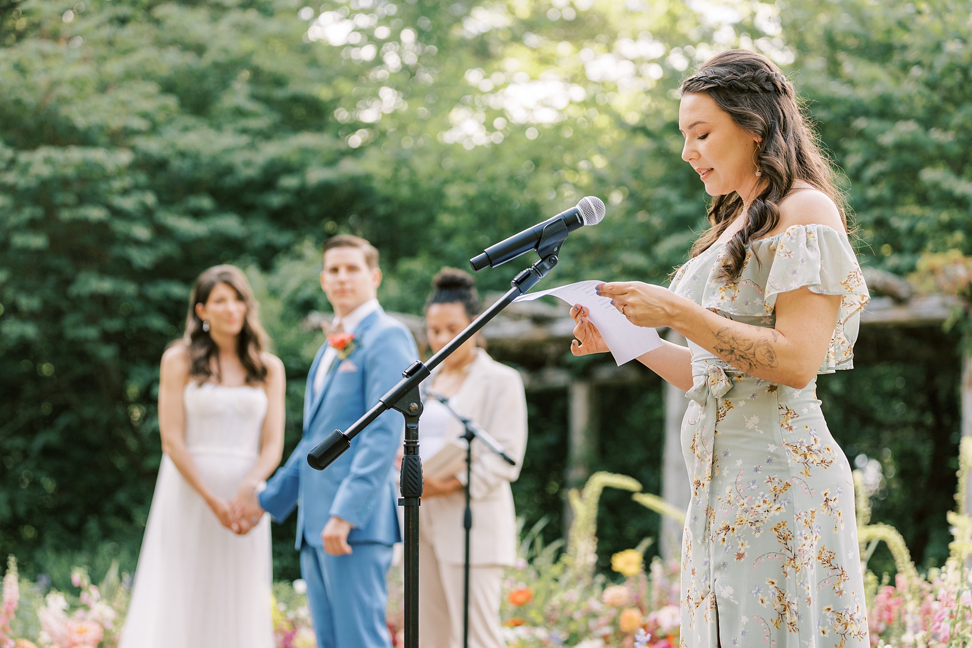 bridesmaid reads during wedding ceremony in garden at Bowman's Hill Wildflower Preserve