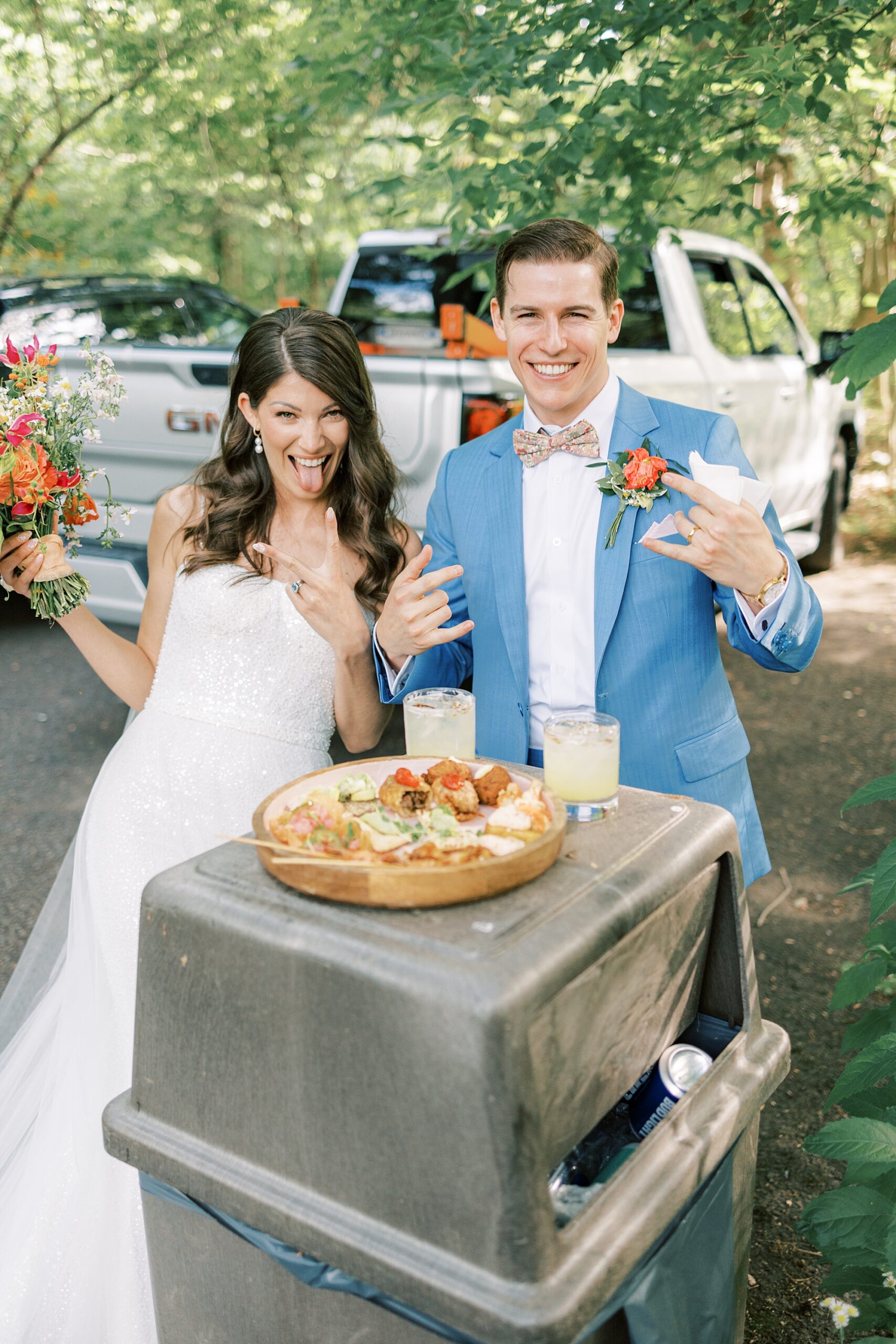 newlyweds grin next to food from food truck at Bowman's Hill Wildflower Preserve