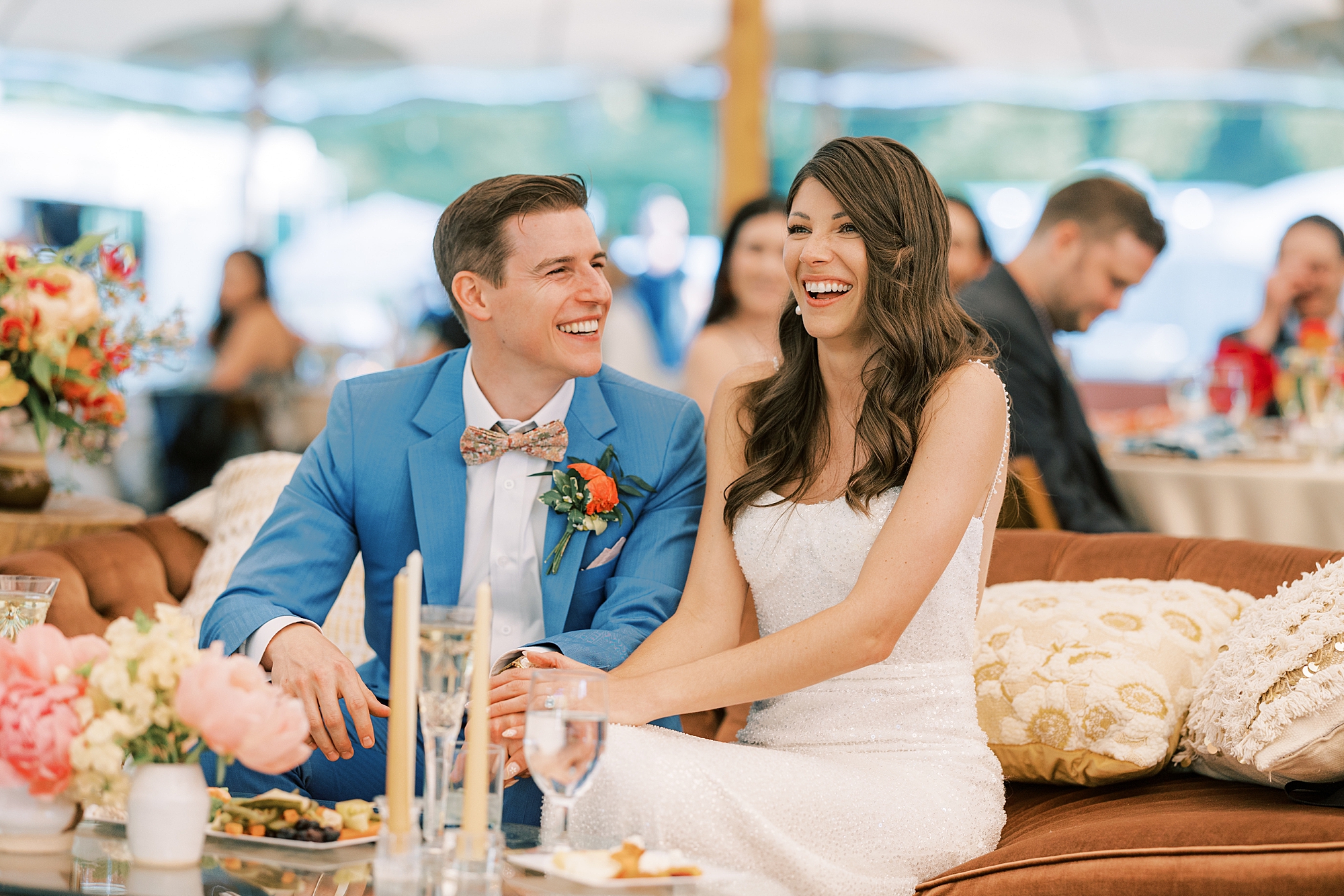 bride and groom laugh together sitting on sofa during reception at Bowman's Hill Wildflower Preserve