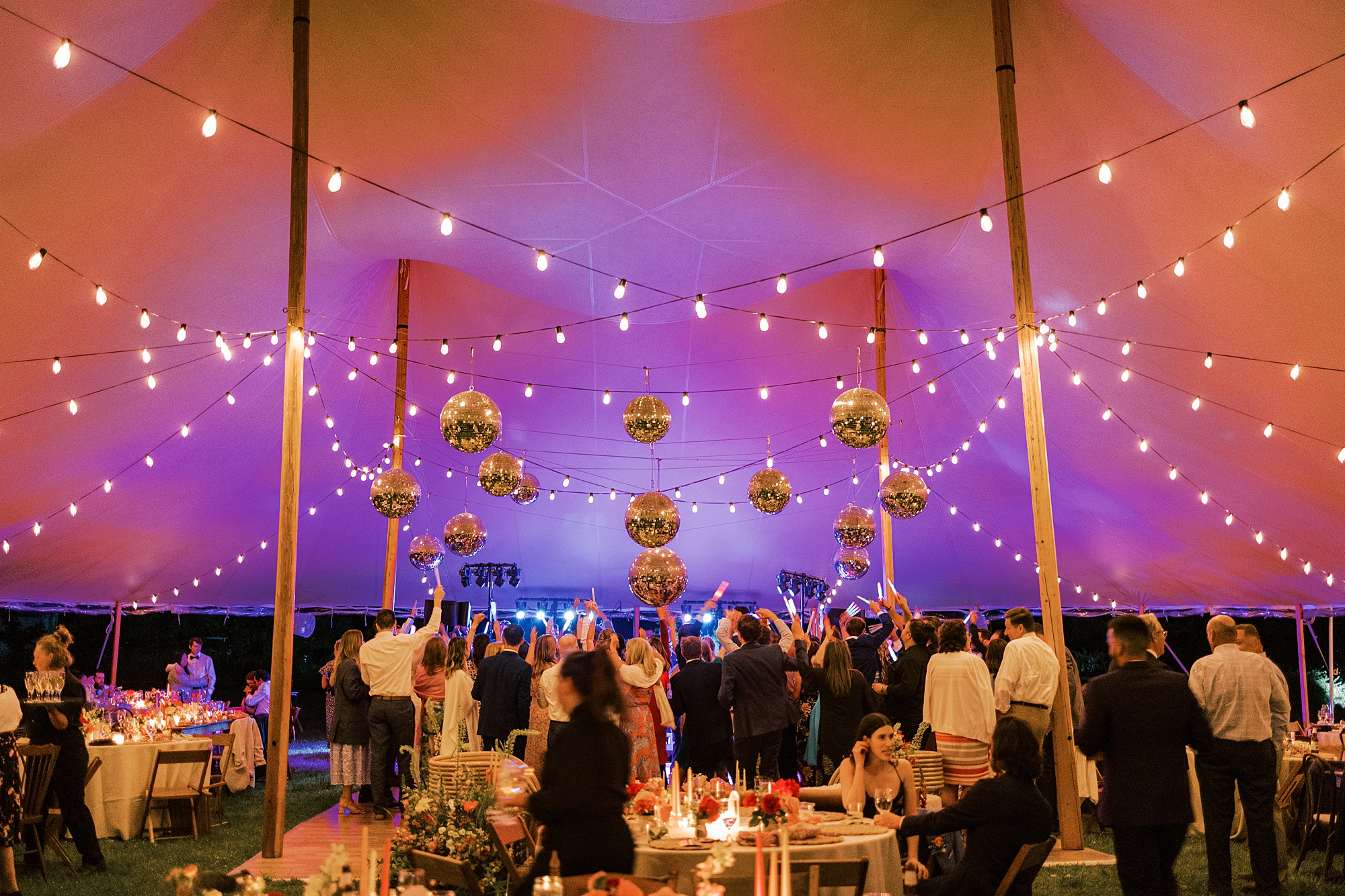 tented wedding reception with purple and pink uplighting 