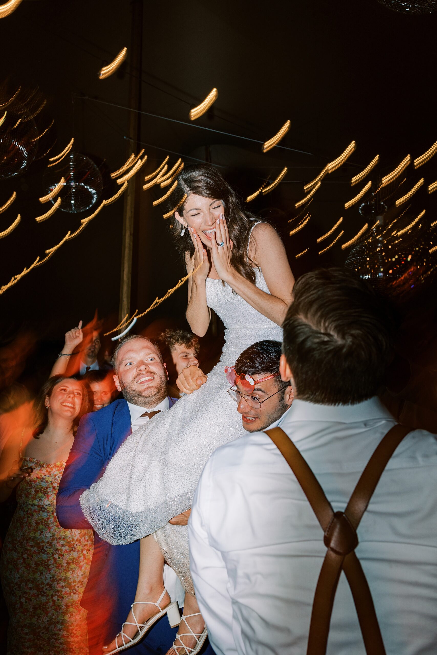 bride grins at guests lifting her up during silent disco at Bowman's Hill Wildflower Preserve