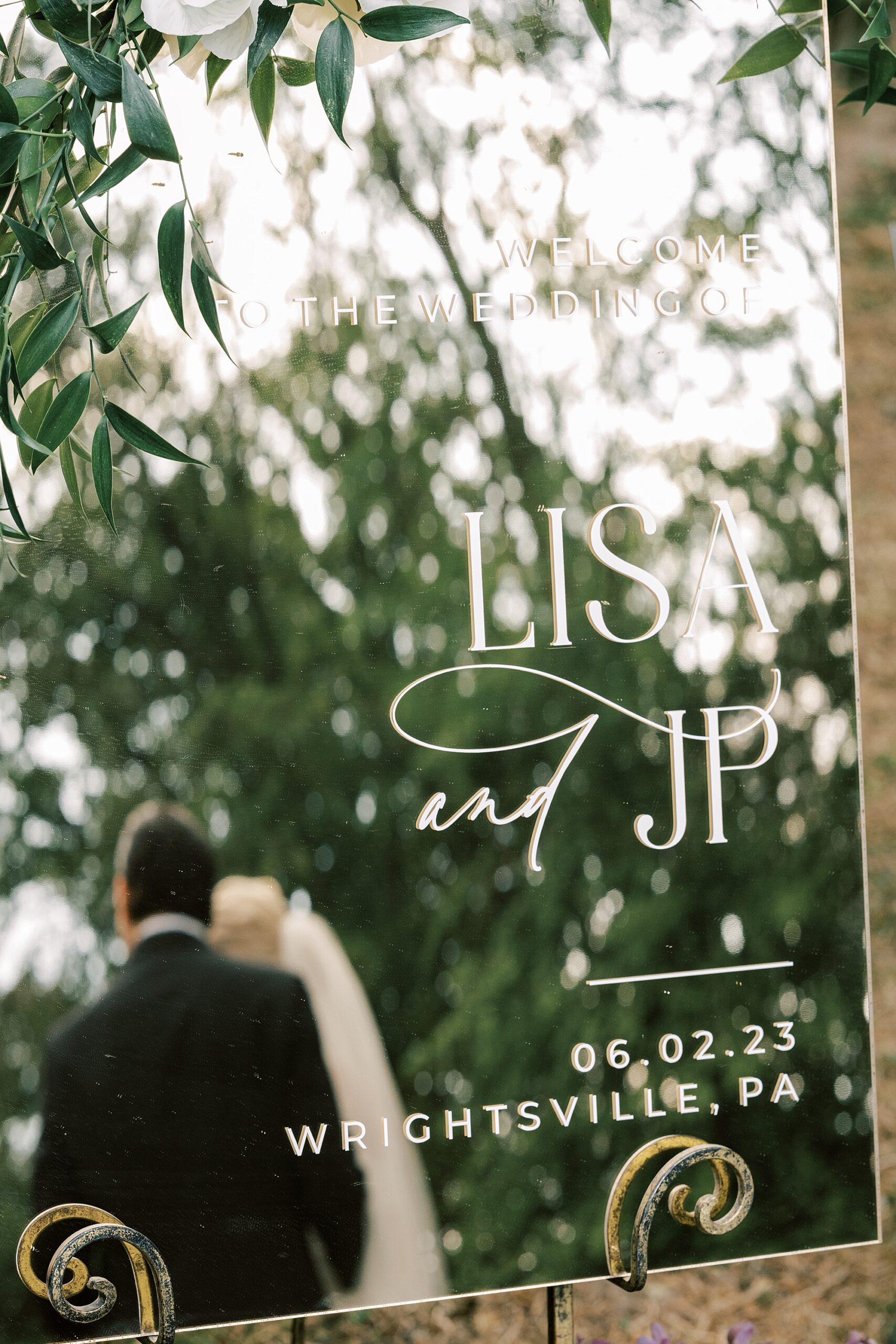 newlyweds hug in reflection of mirror with couple's names