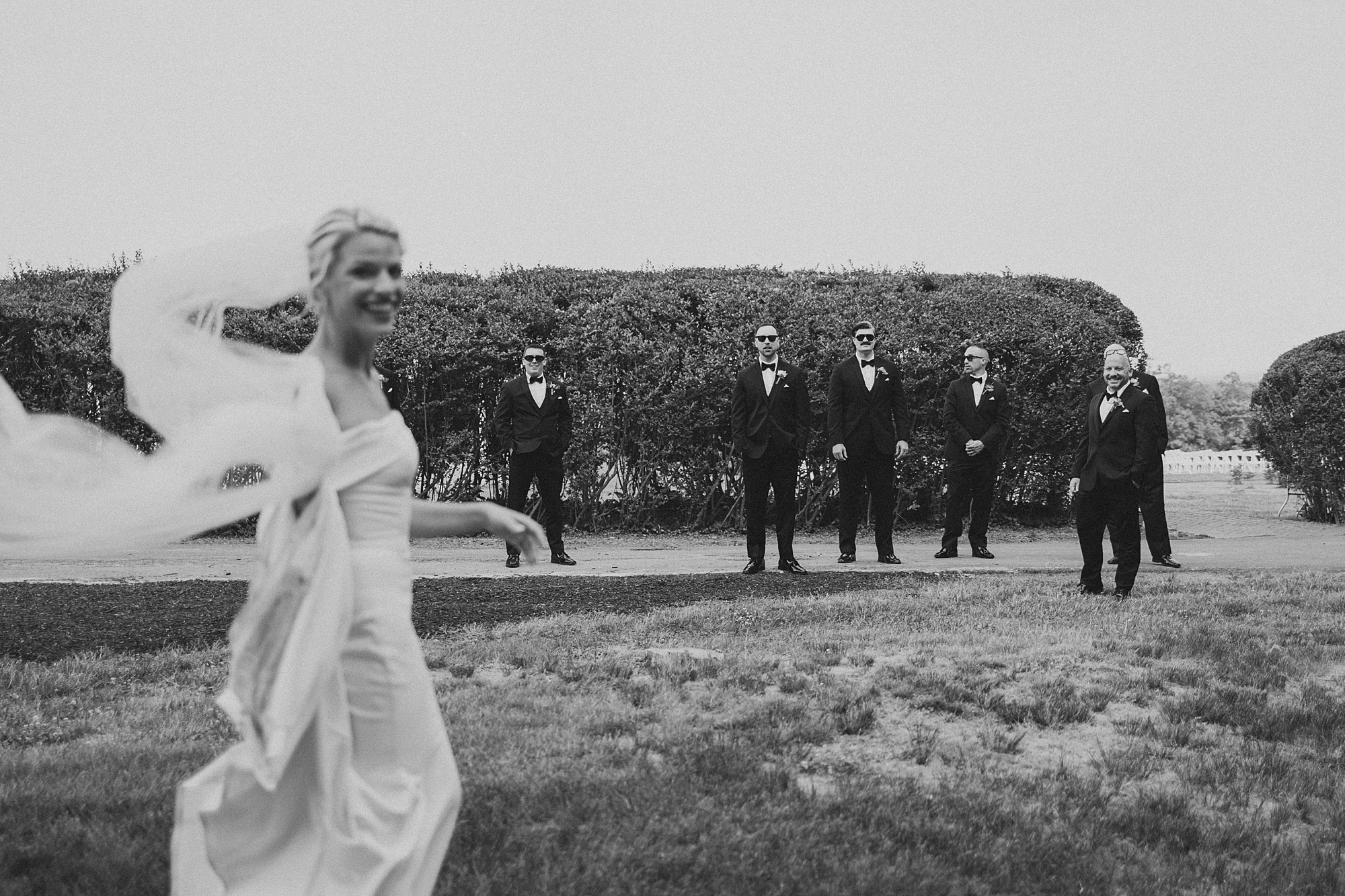 groomsmen watch bride walk on lawn at Lauxmont Farms
