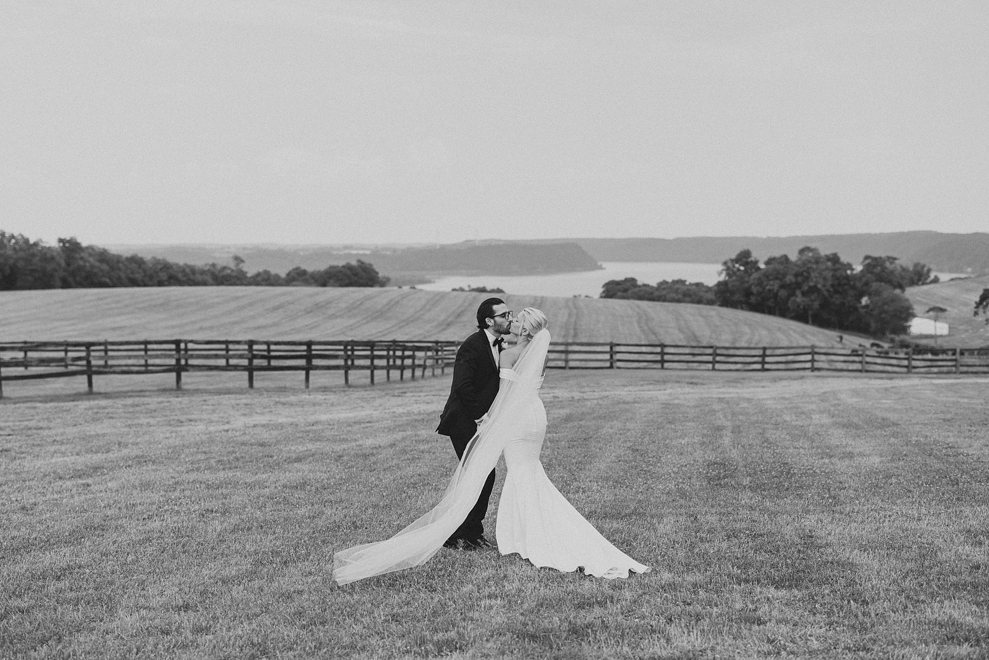 newlyweds kiss on lawn in front of mountains in Pennsylvania