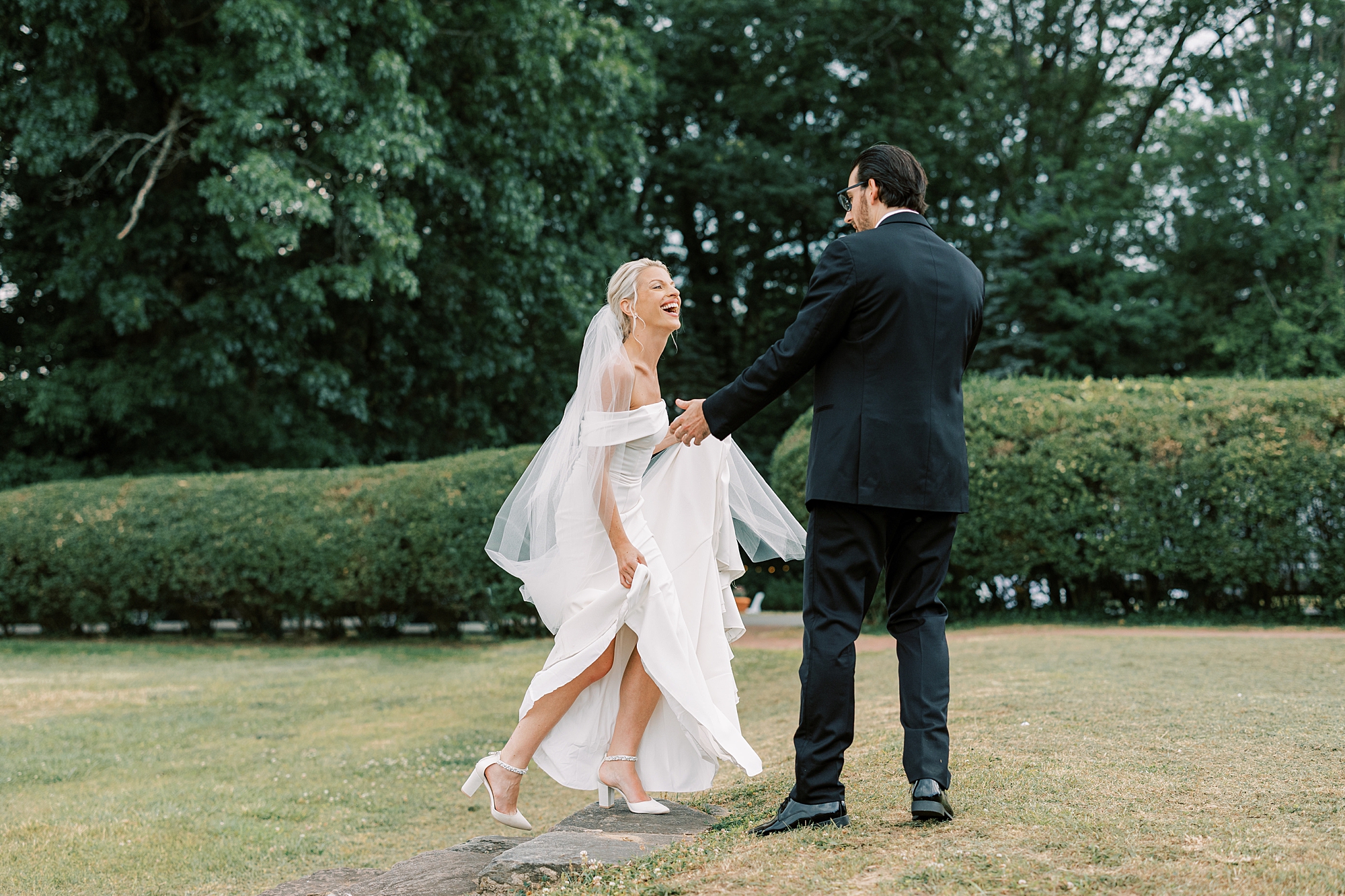 newlyweds laugh walking on lawn at Lauxmont Farms