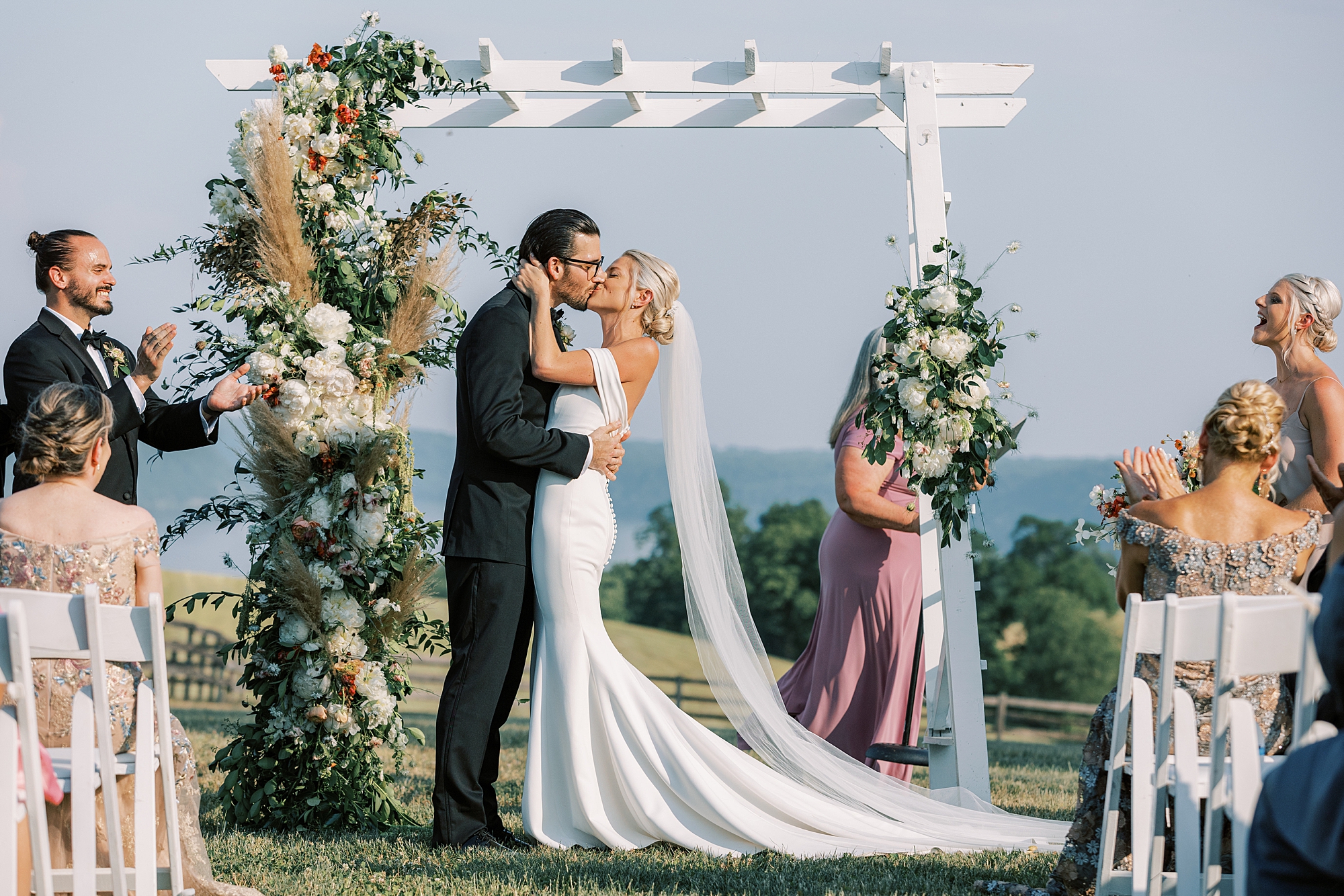 newlyweds kiss during ceremony on lawn at Lauxmont Farms