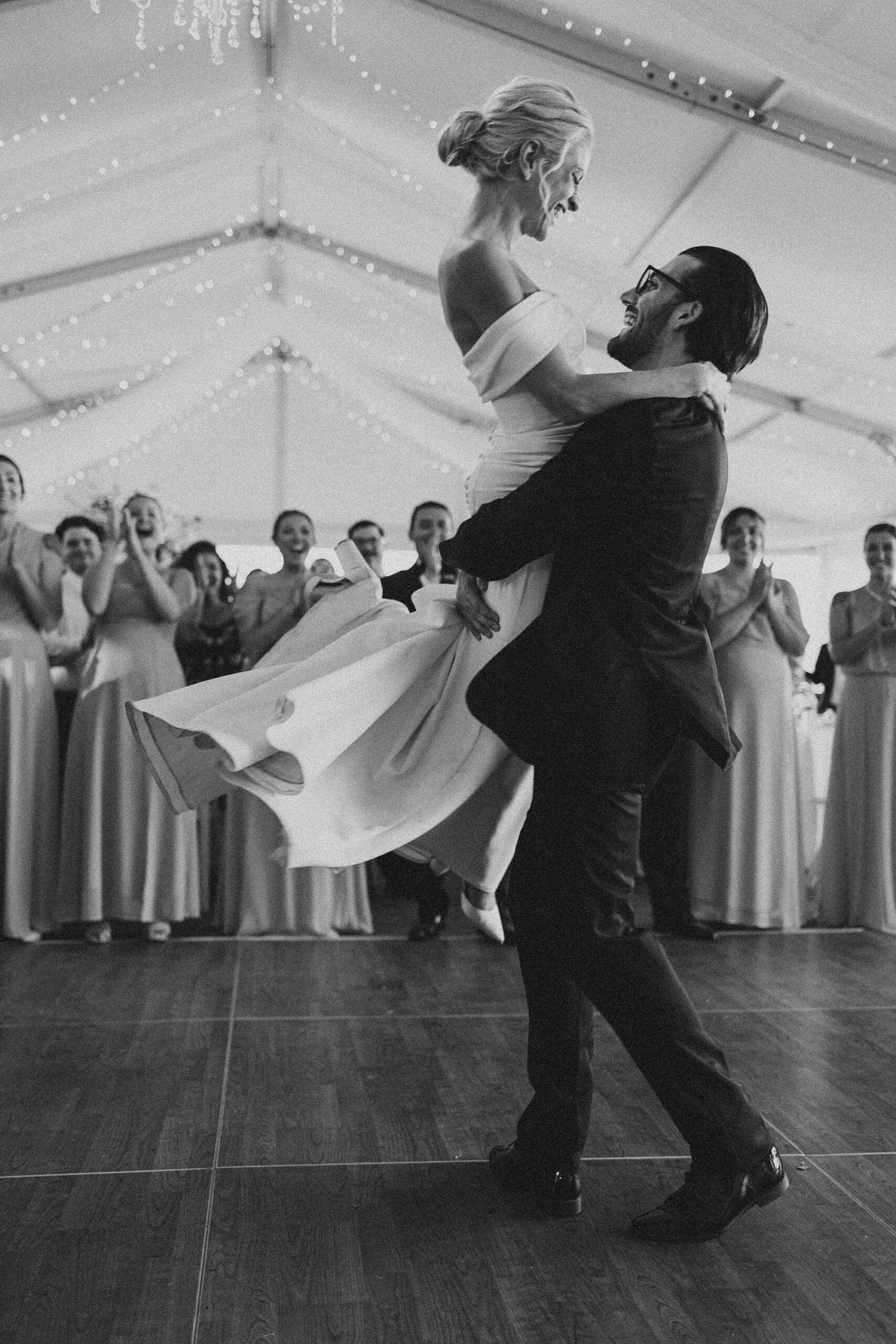 groom twirls bride on dance floor during wedding reception at Lauxmont Farms