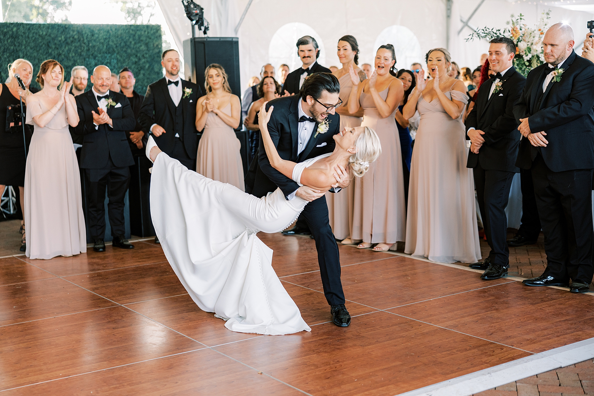 groom dips bride during first dance during wedding reception at Lauxmont Farms