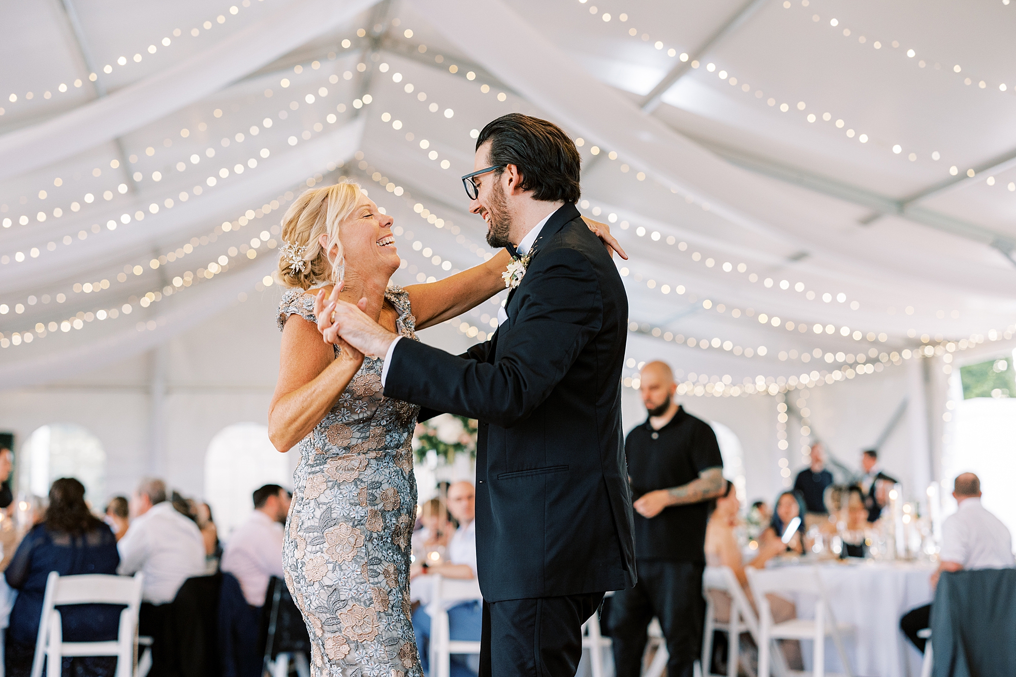 groom laughs dancing with mom during wedding reception at Lauxmont Farms