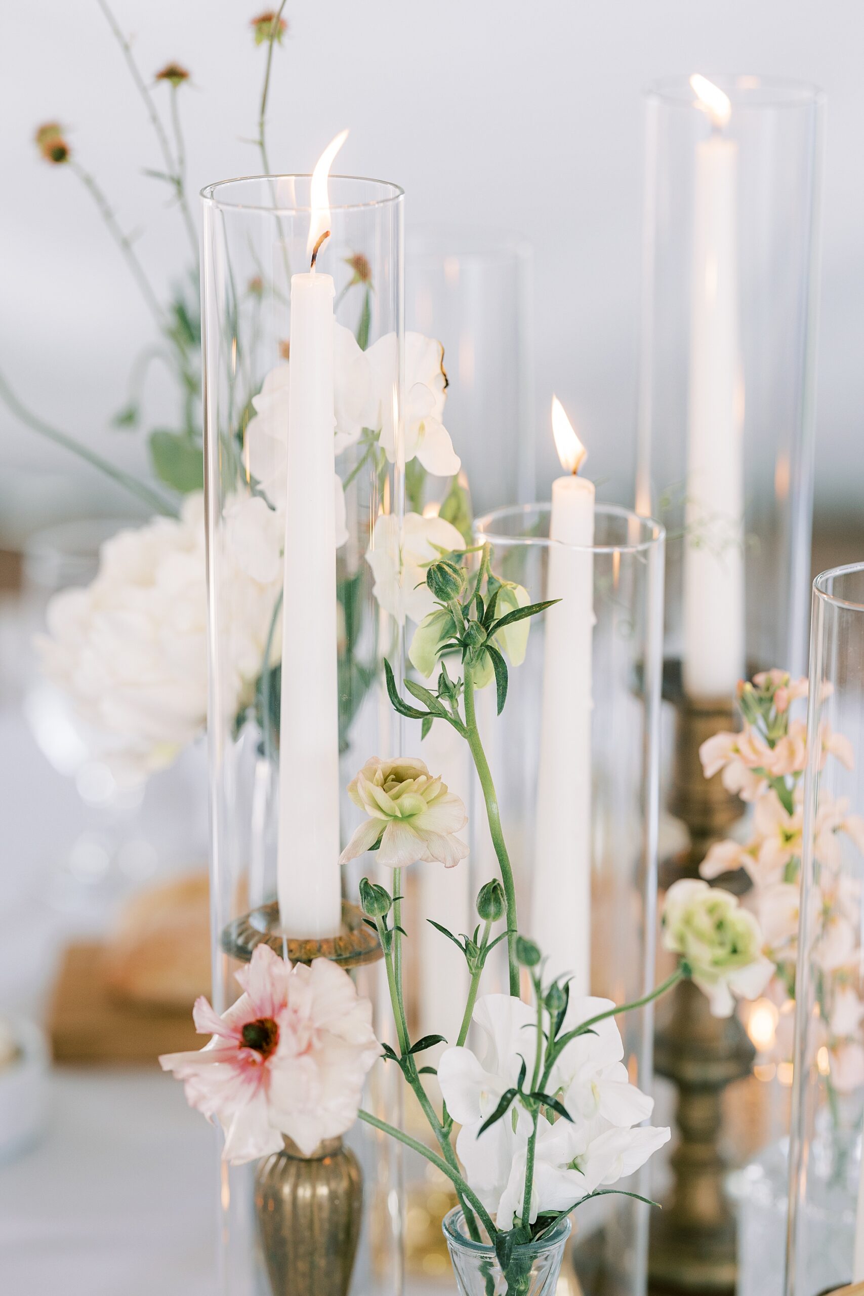 white taper candles in glass containers with pastel flowers at Wrightsville PA Wedding reception