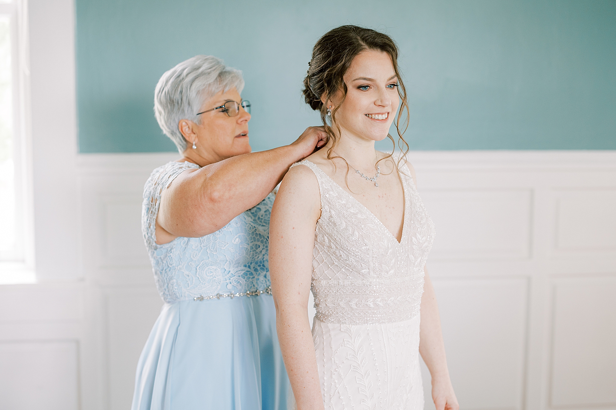 mother helps bride with jewelry on morning of her wedding at Bellevue Hall