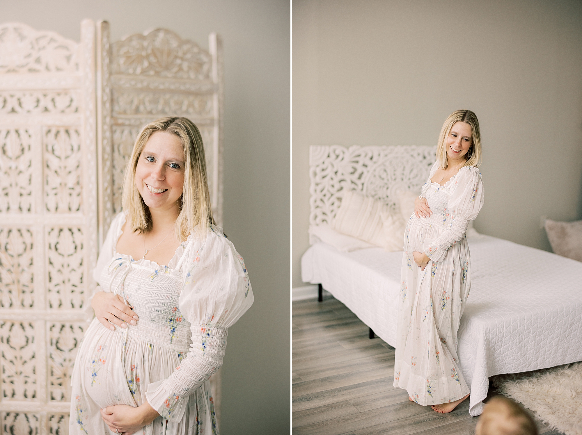 blonde woman stands by white bed holding baby bump during studio maternity session in Media PA
