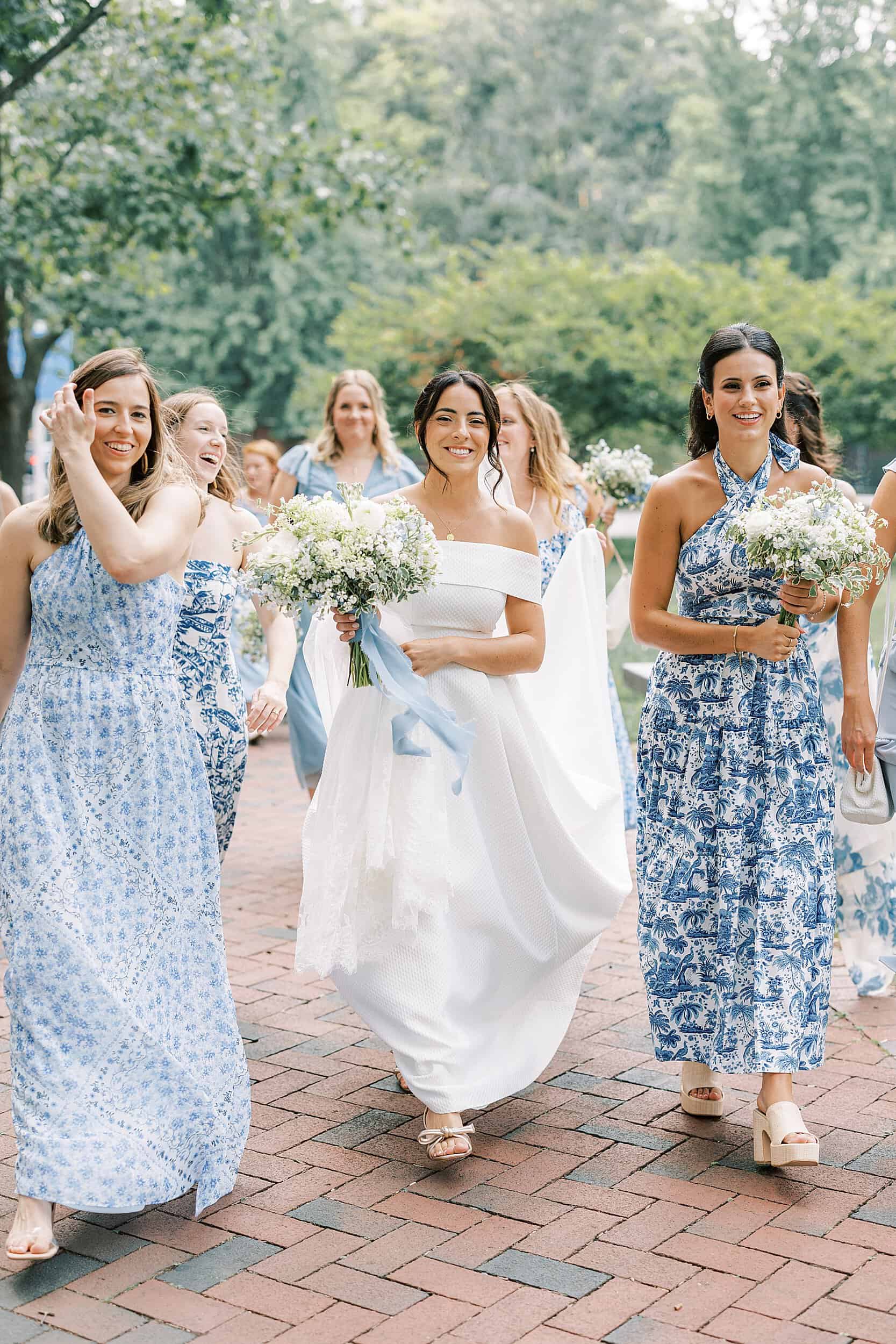 bride walks with bridesmaids in blue and white gowns in Philadelphia PA