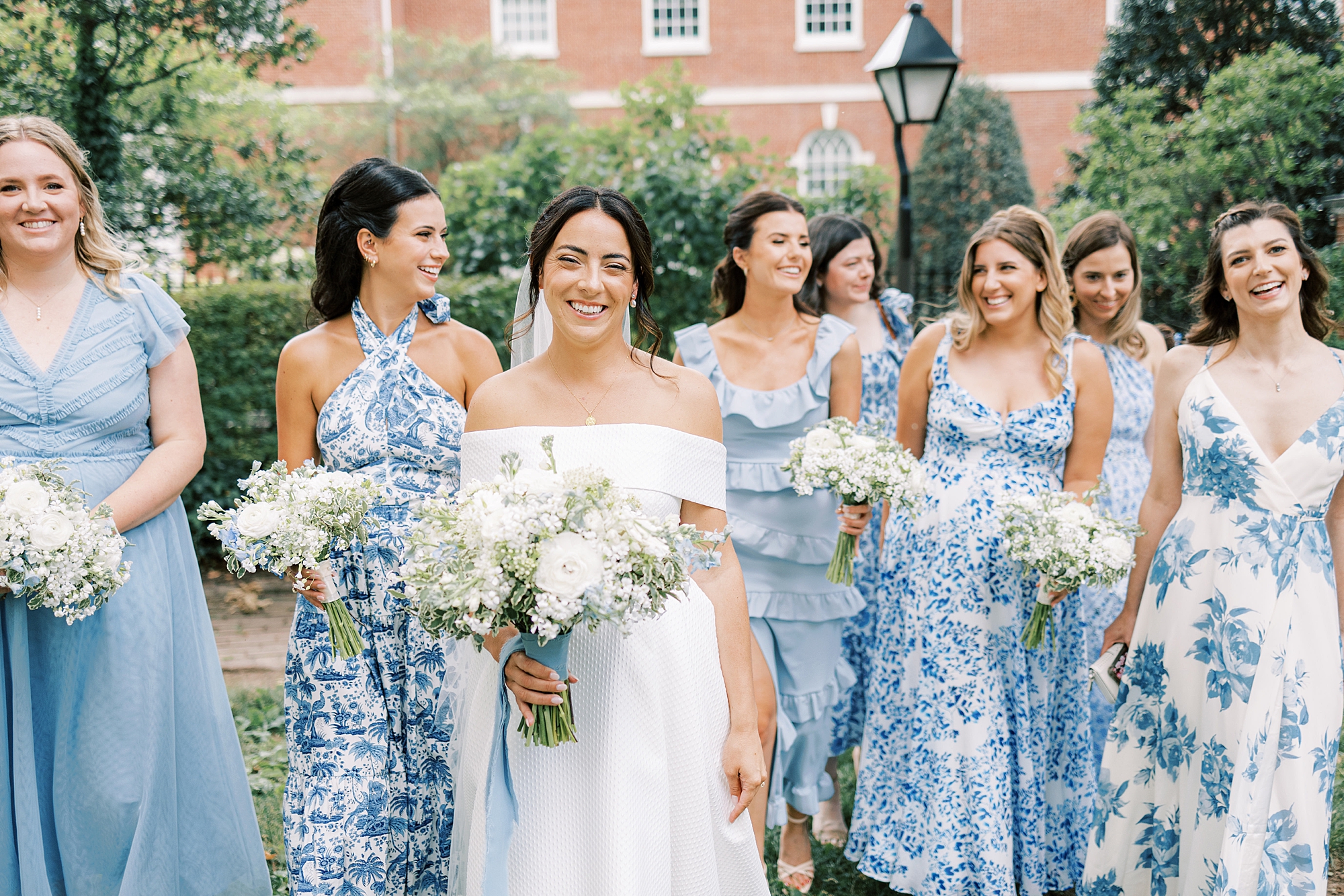 bride walks with bridesmaids in blue and white gowns in Philadelphia PA