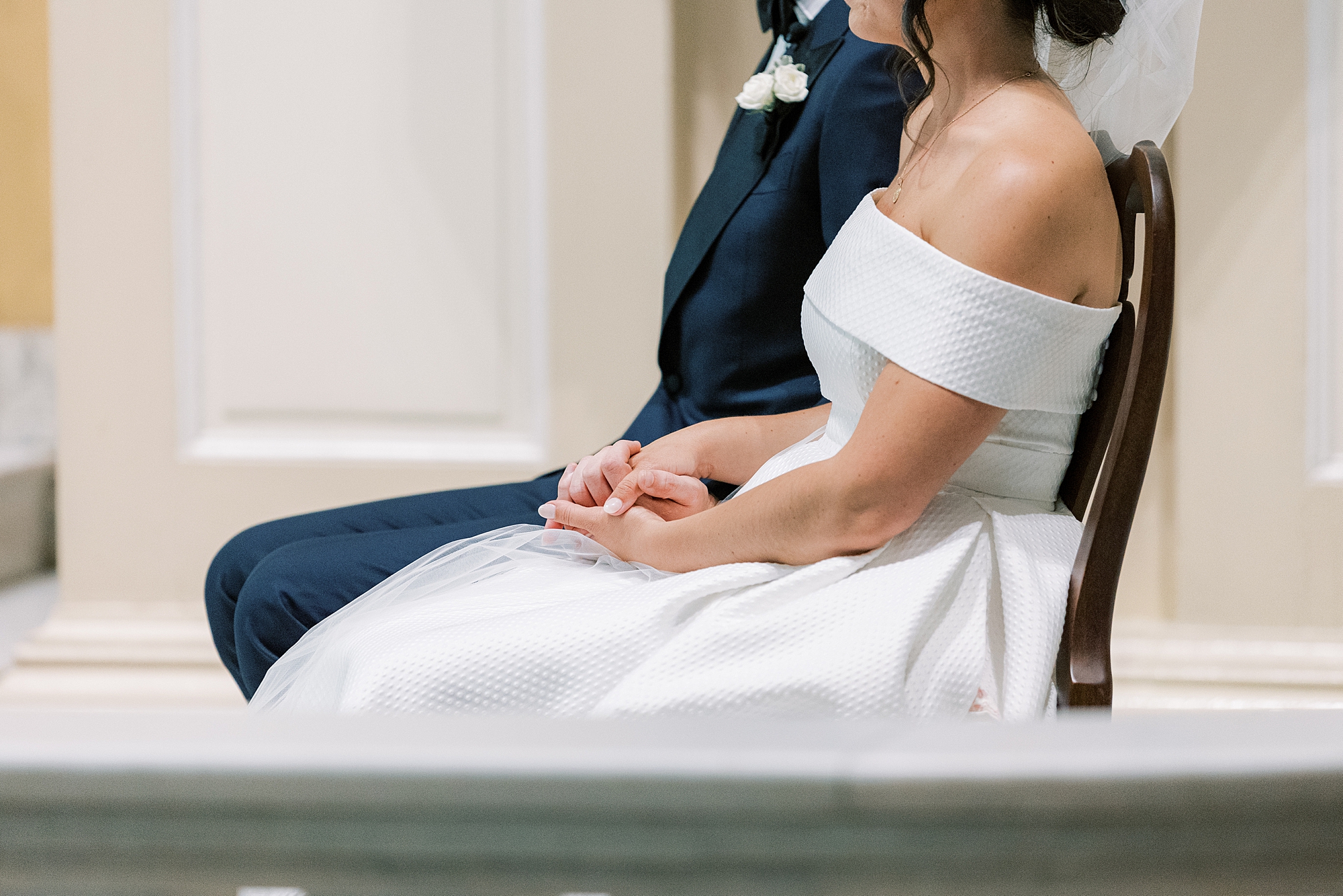 bride holds groom's hand during ceremony at Old St. Joseph’s Catholic Church in Philadelphia PA