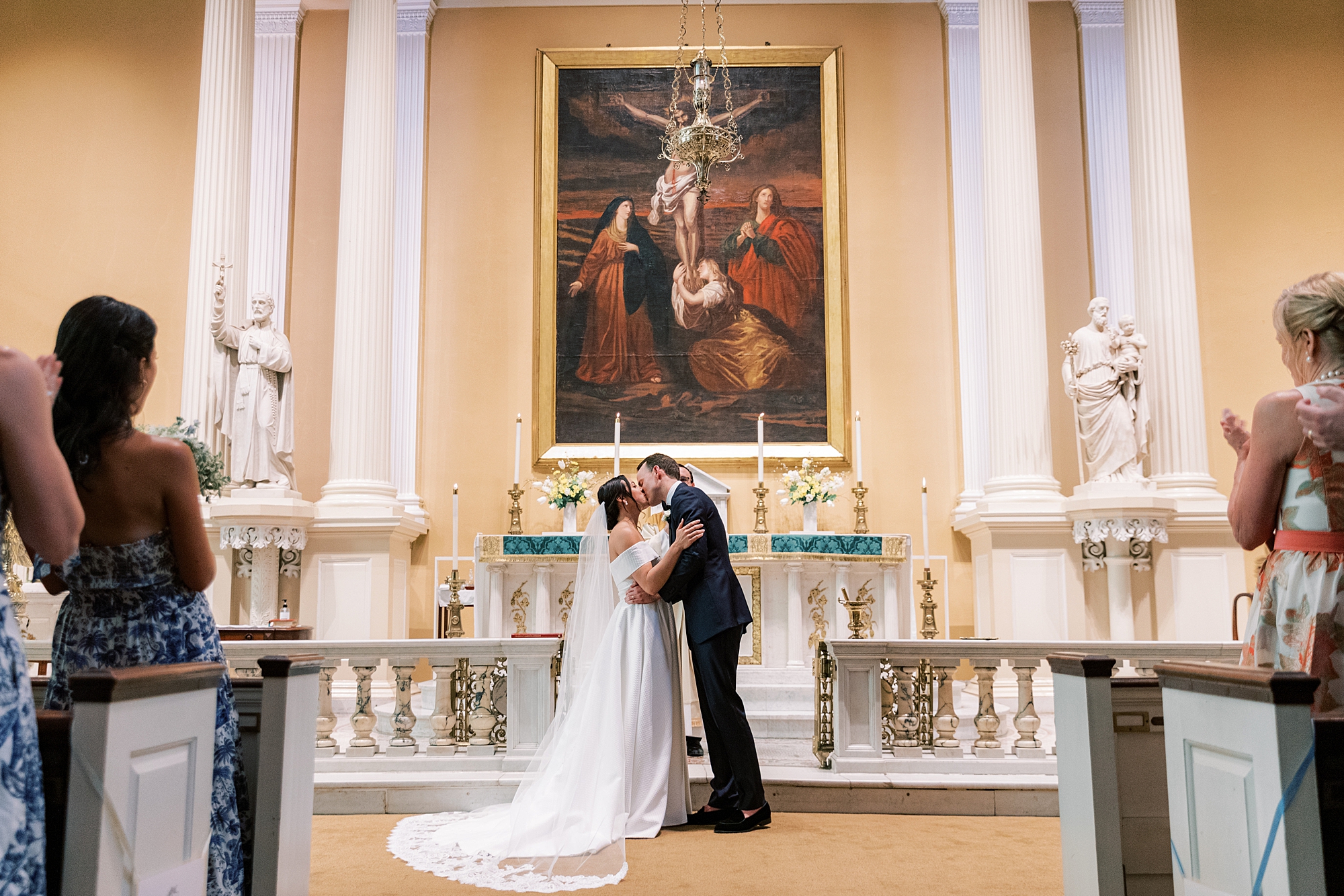 bride and groom kiss during ceremony at Old St. Joseph’s Catholic Church in Philadelphia PA