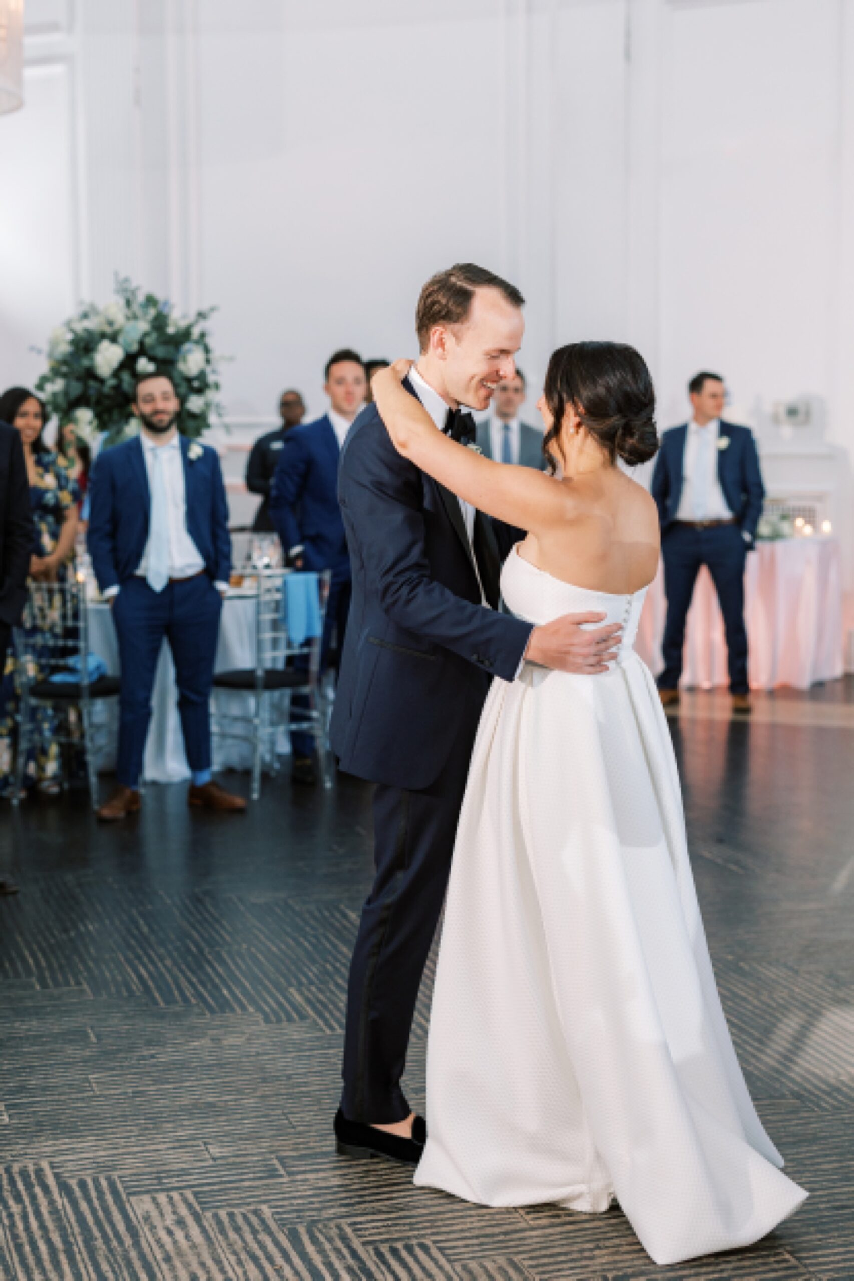 groom smiles at his bride while they share their first dance