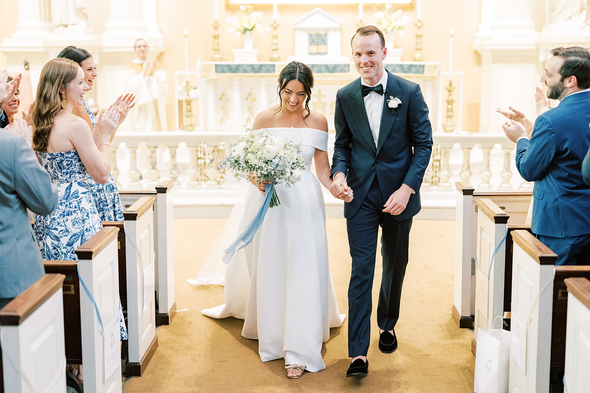 bride and groom walk up aisle after ceremony at Old St. Joseph’s Catholic Church in Philadelphia PA