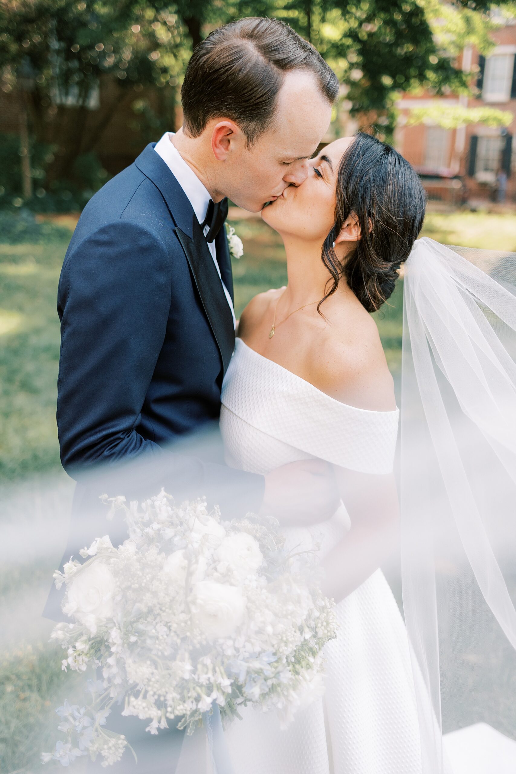 bride and groom kiss surrounded by the bride's cathedral length veil after their Philadelphia wedding ceremony