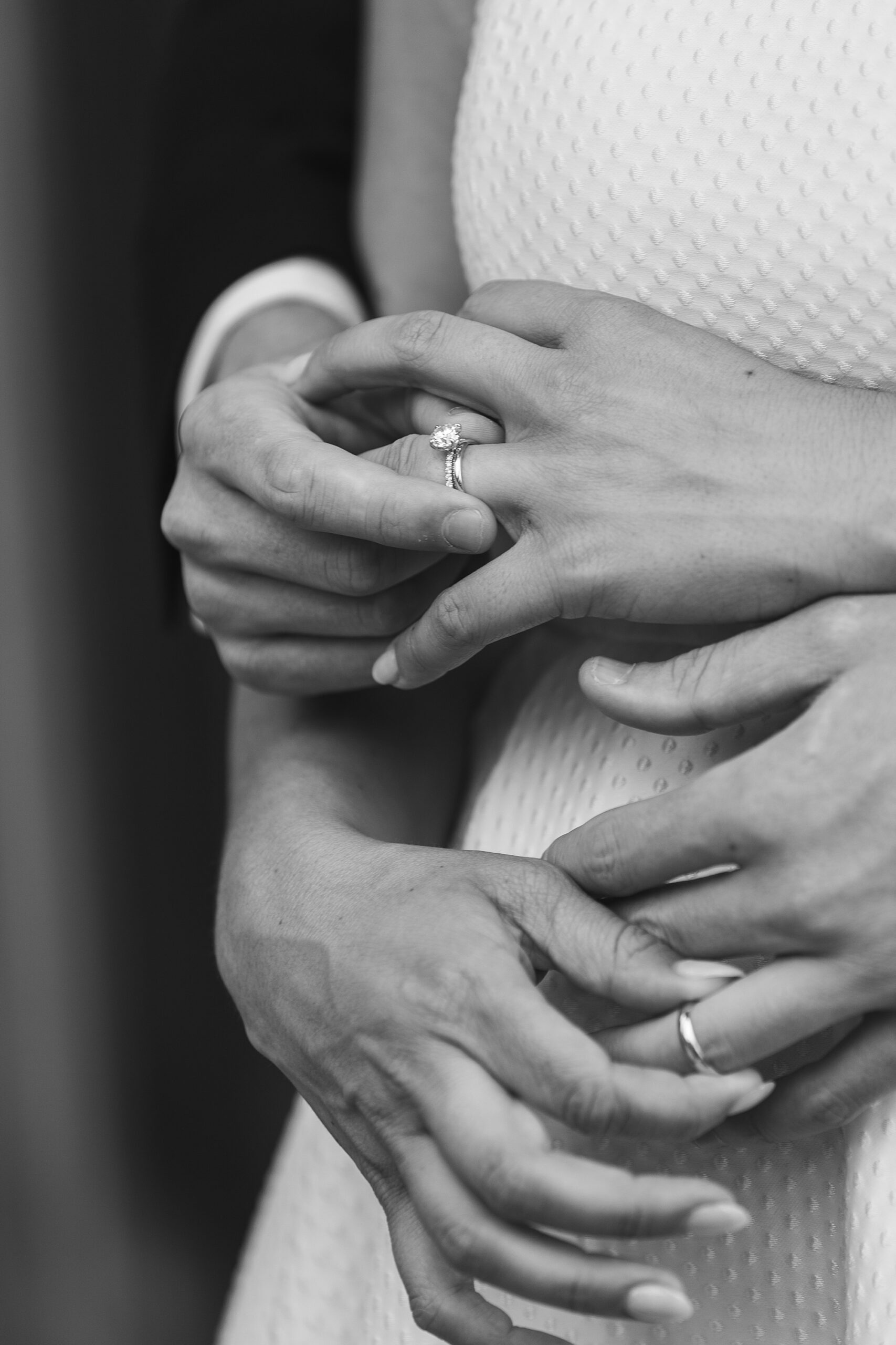 detail photo of bride and groom putting rings on each other's fingers