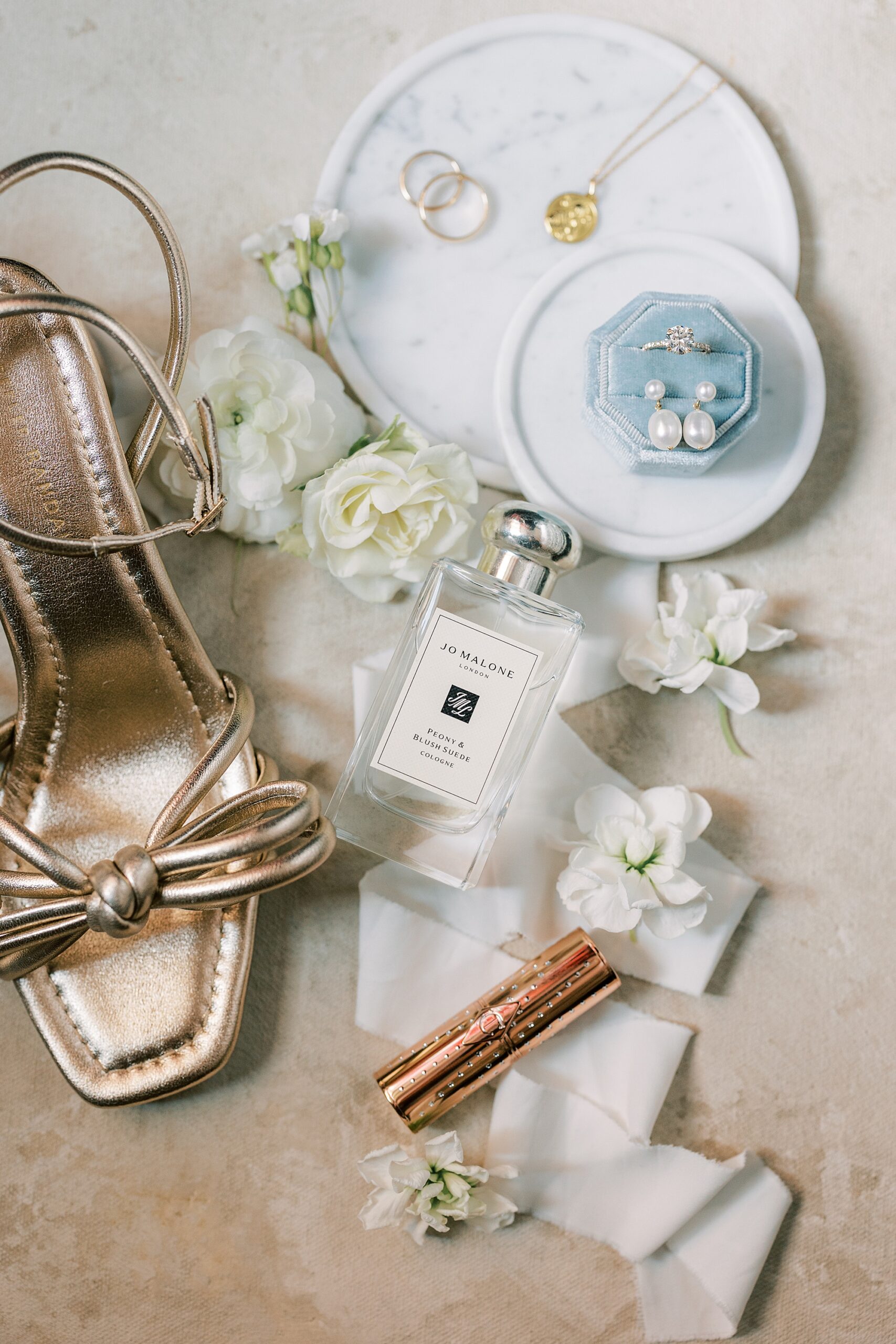 bride's gold shoes with jewelry, flowers, and perfume 