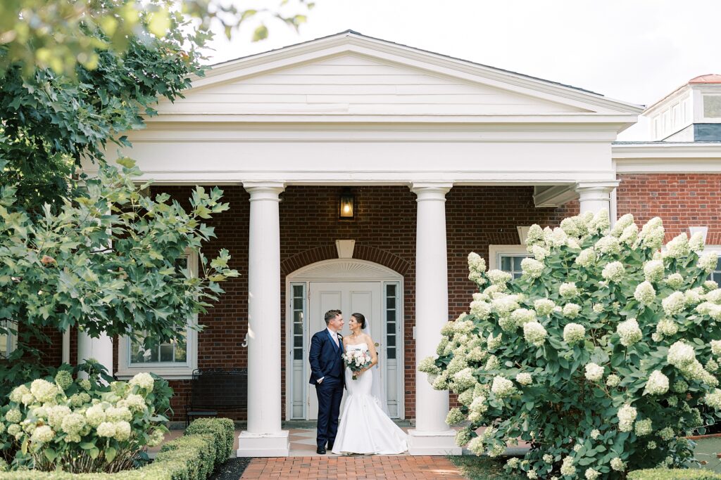bride and groom pose on front steps of the Philadelphia Cricket Club