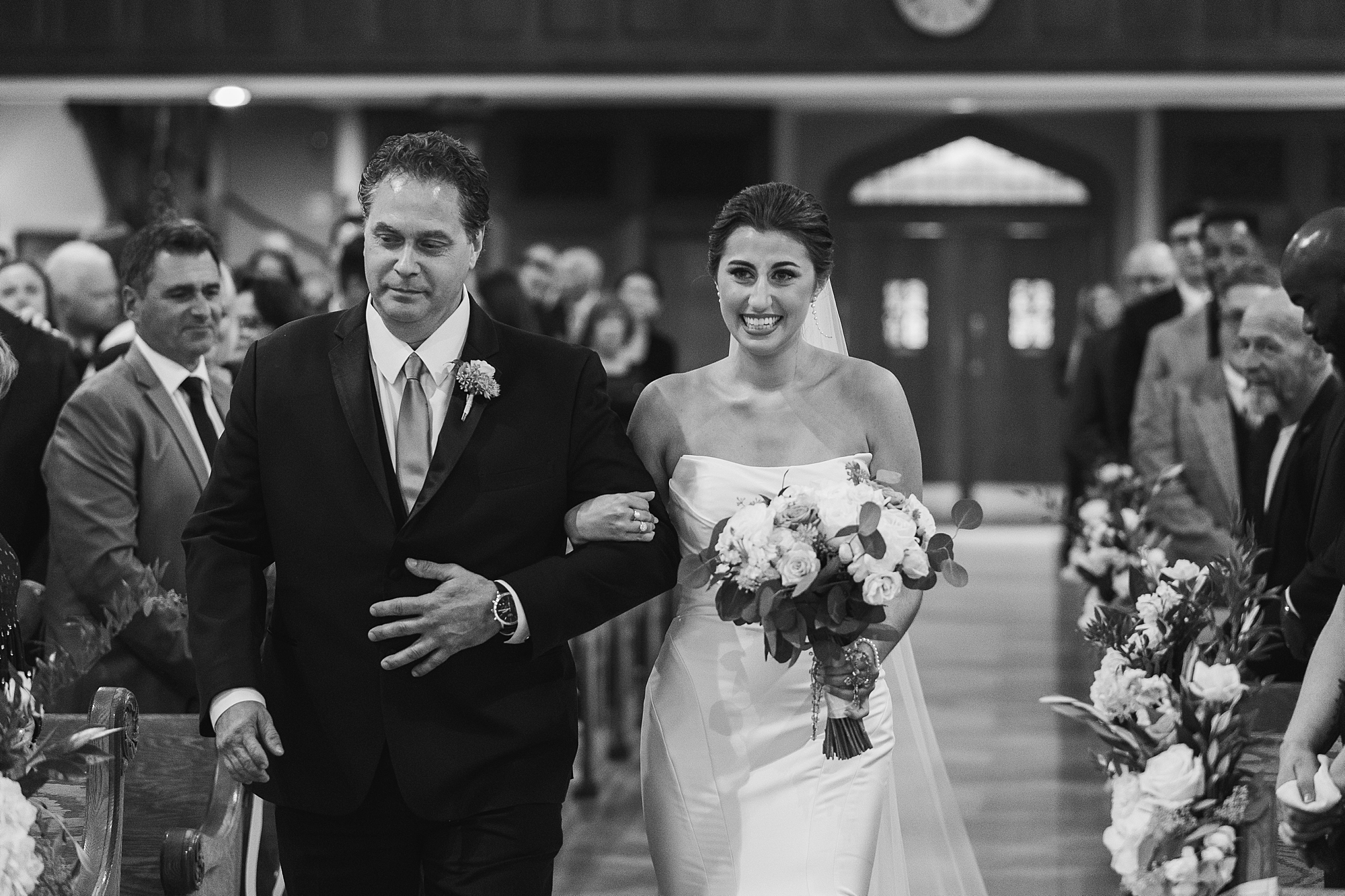 bride and father walking up aisle during traditional wedding ceremony at Philadelphia PA church