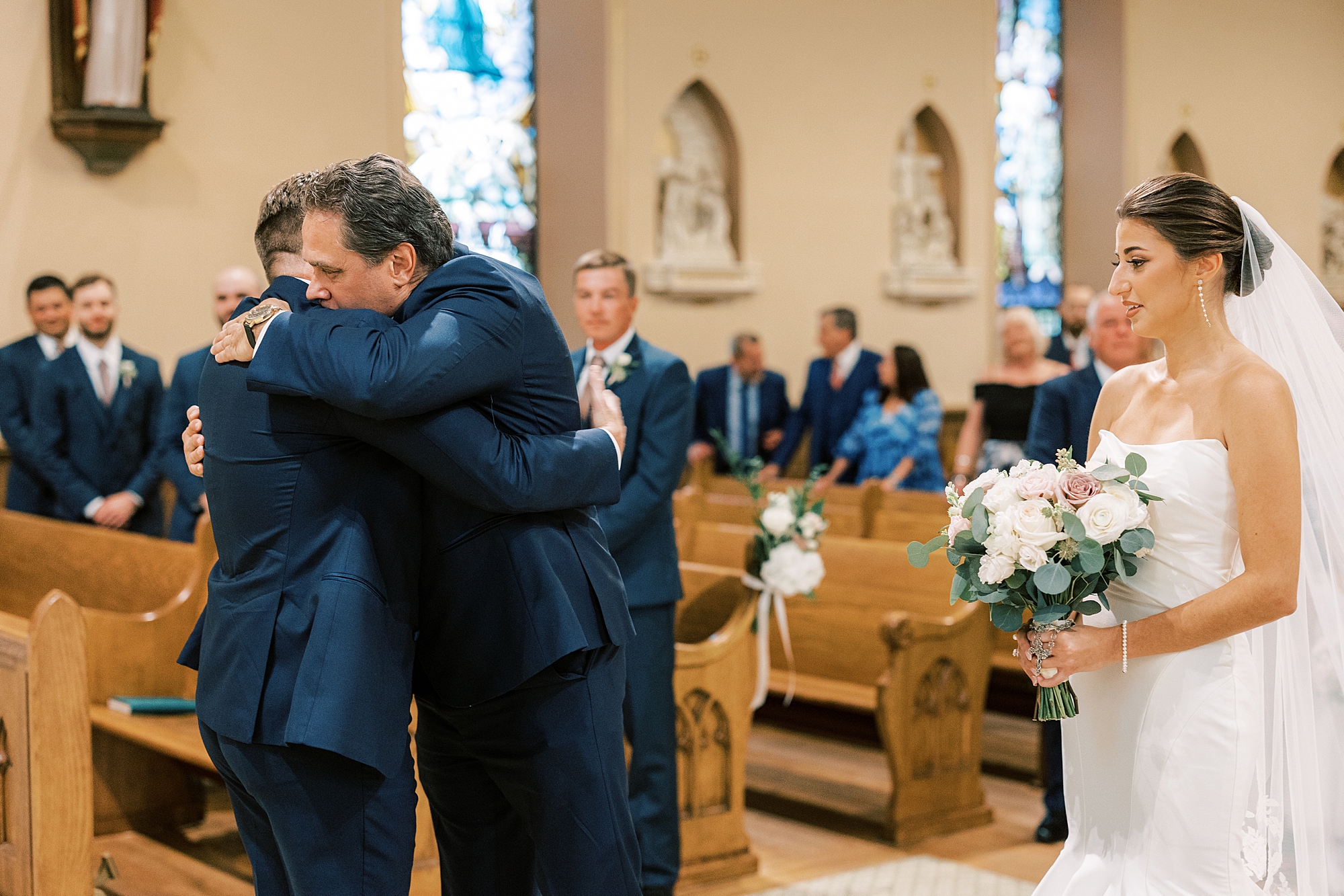 father hugs groom during traditional wedding ceremony at Philadelphia PA church