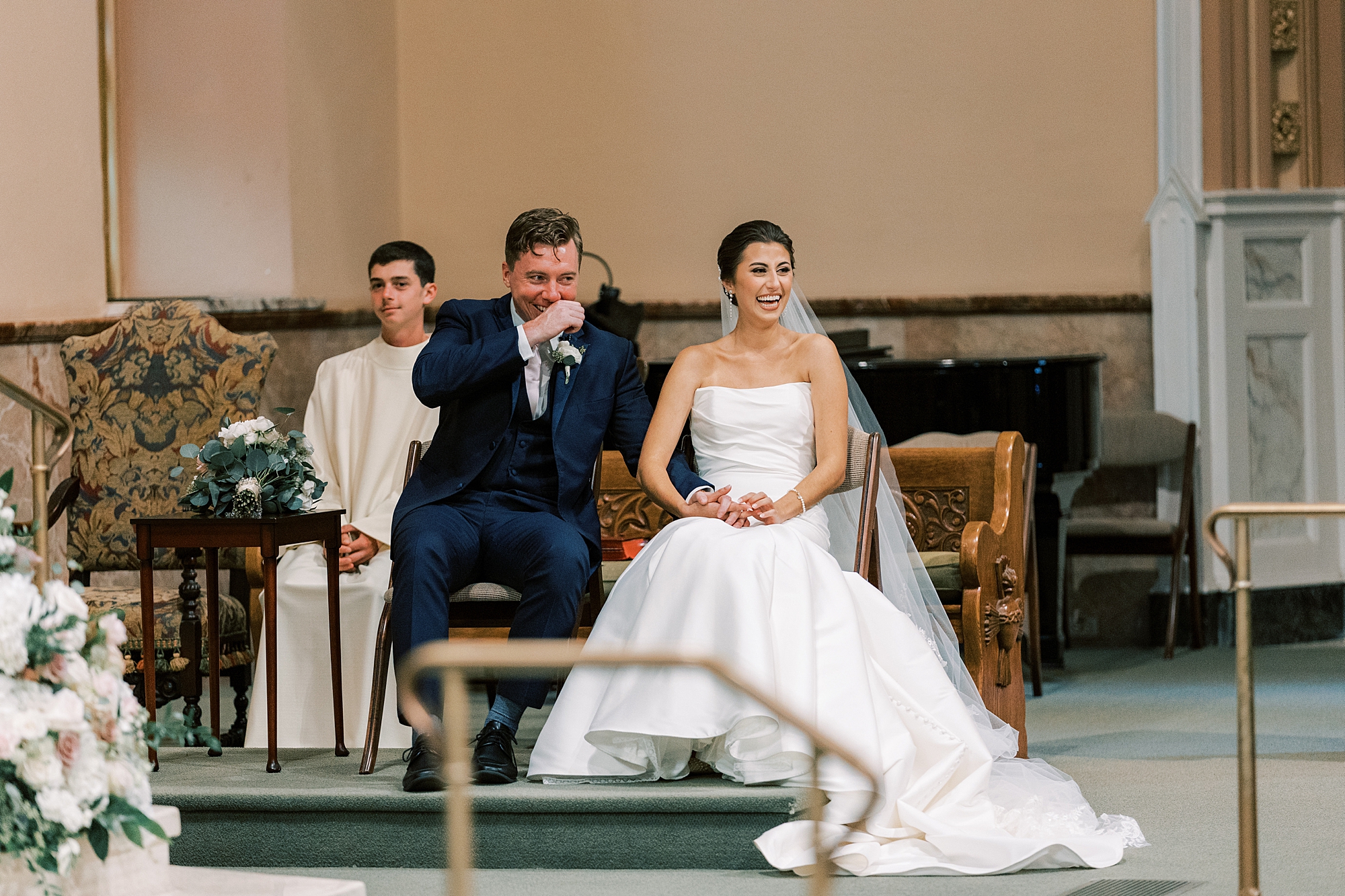 bride and groom sit together during traditional wedding ceremony at Philadelphia PA church