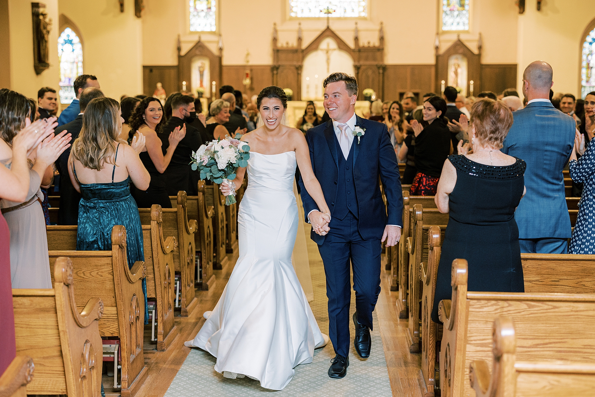 bride and groom hold hands walking through Philadelphia PA church