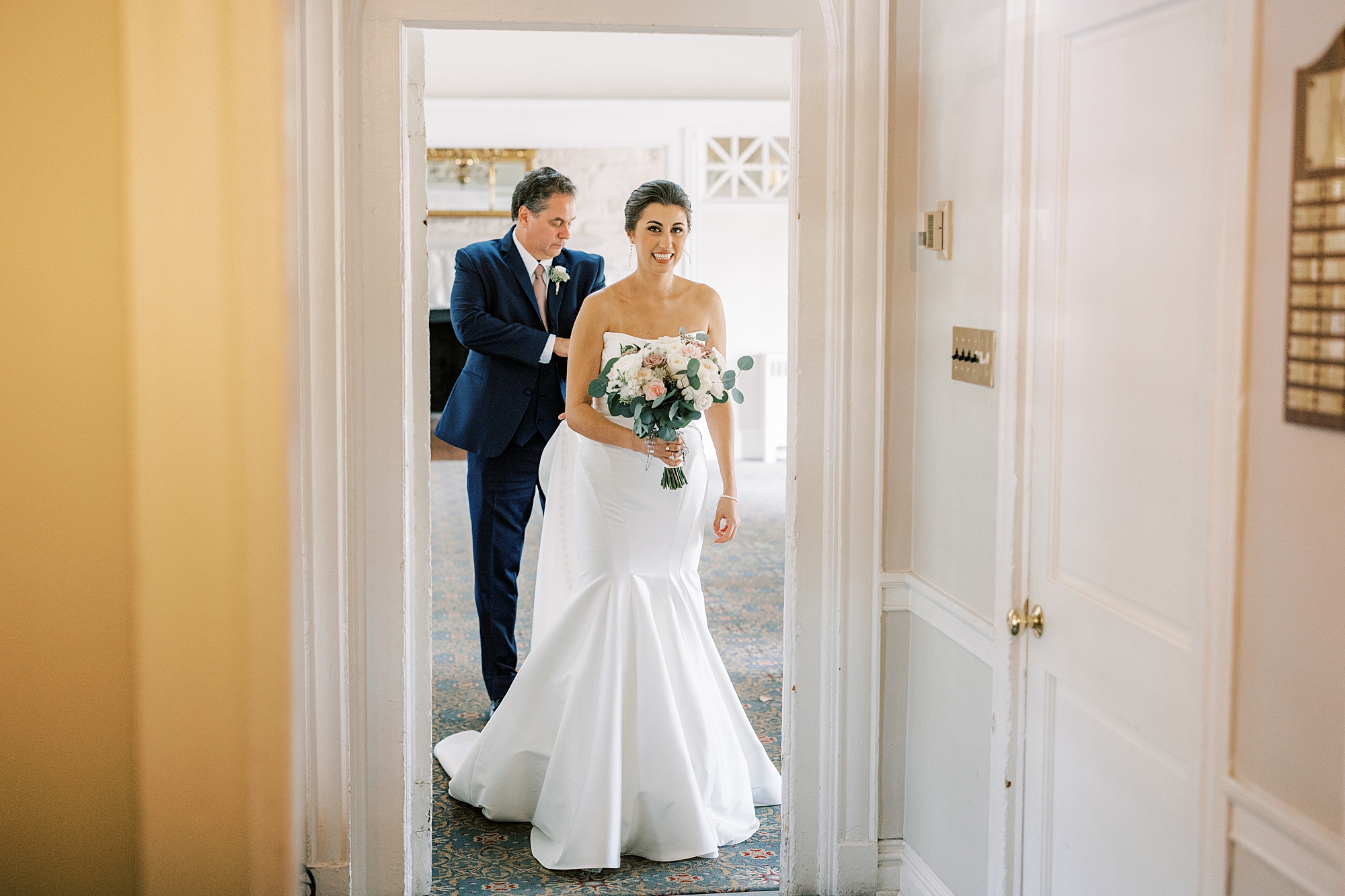 father helps bride with wedding dress inside the Philadelphia Cricket Club
