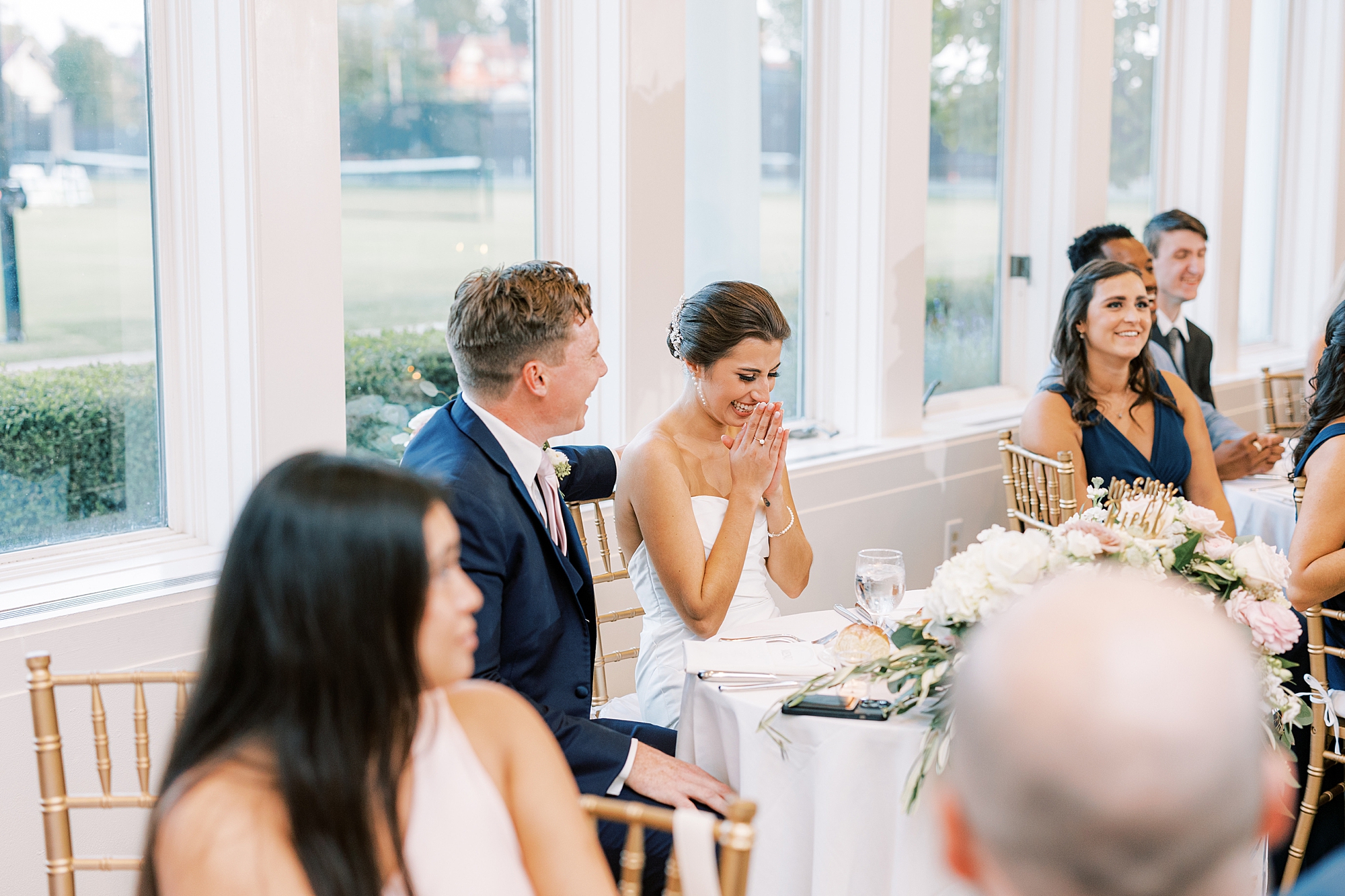 bride grins looking at table during speeches