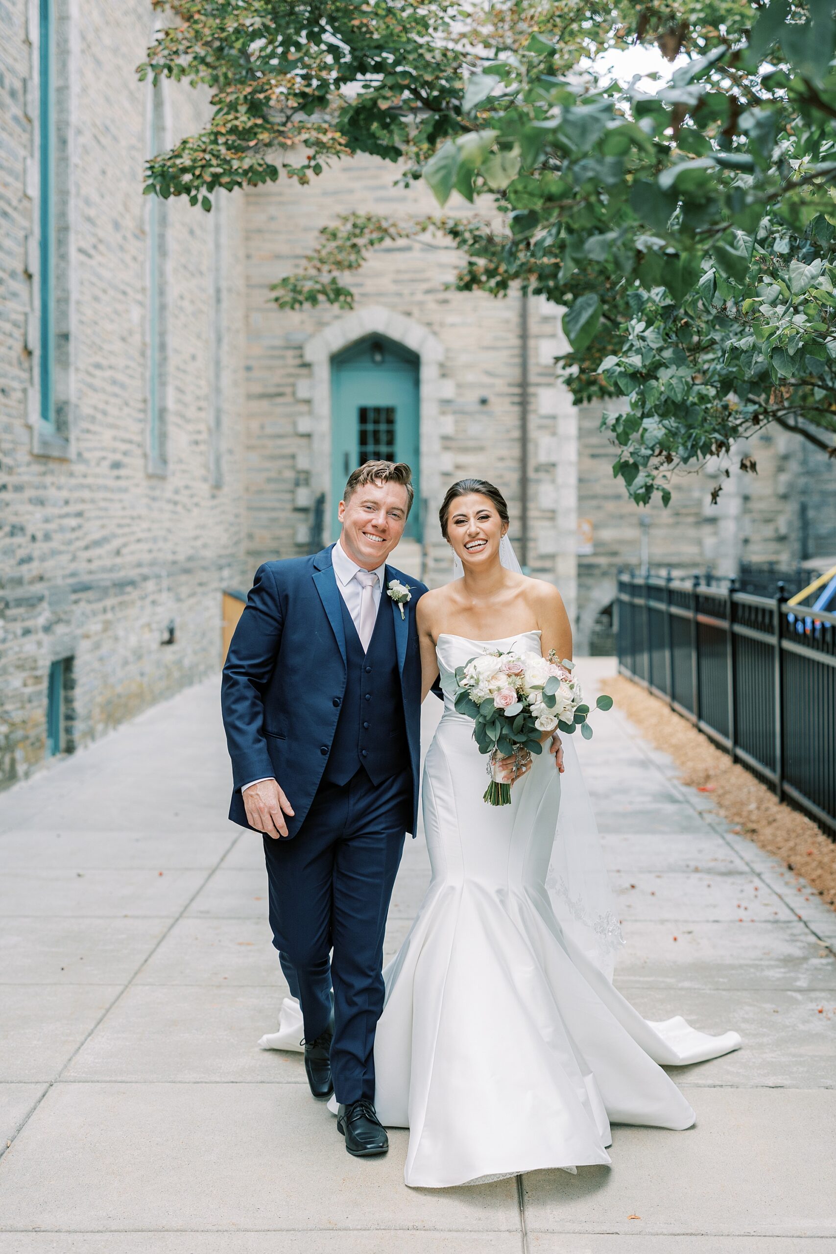 bride and groom walk away from church in Philadelphia PA