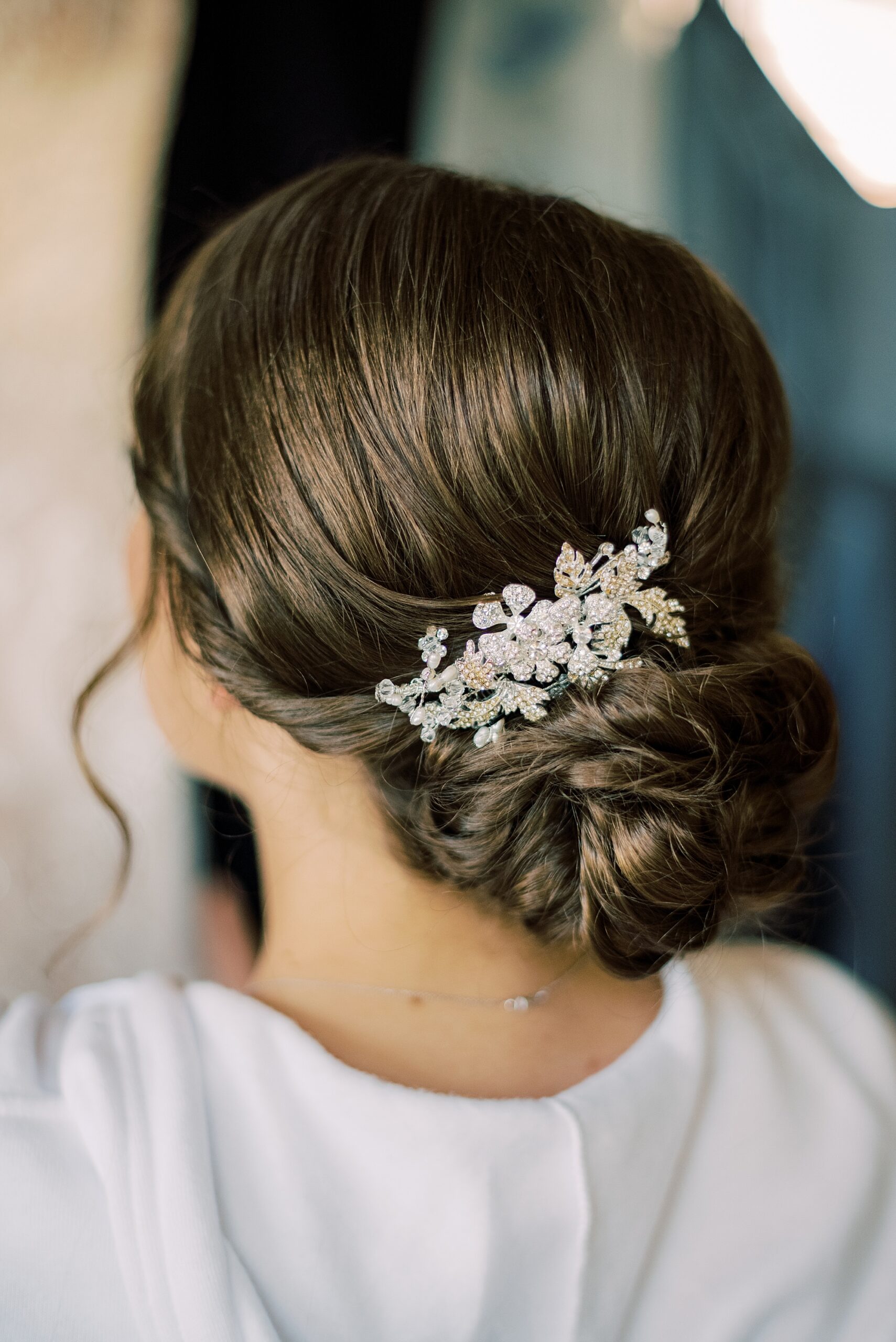 silver flower hairpiece in brunette bride's hair above bun