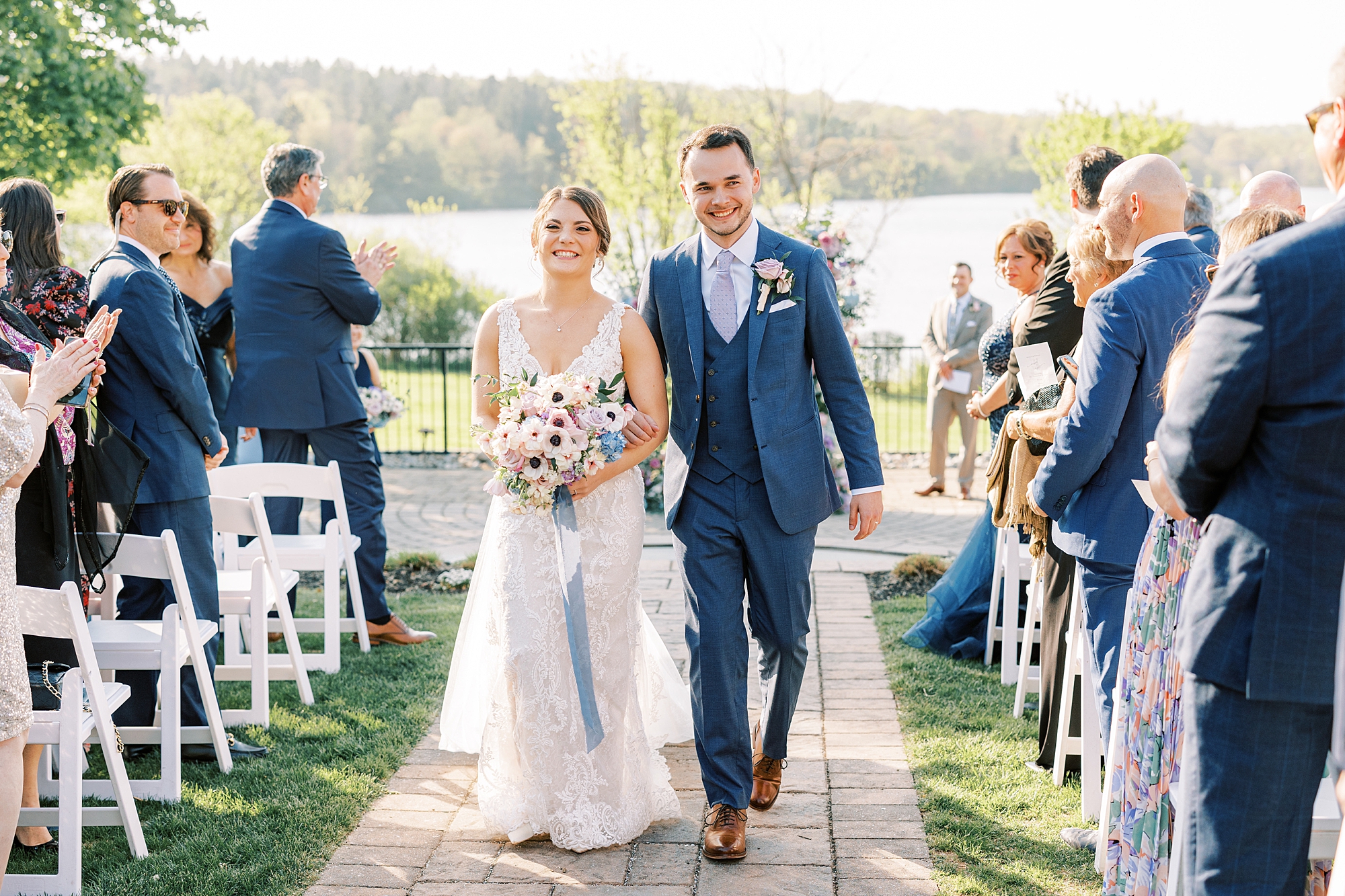 bride and groom walk up aisle after ceremony on lawn at Lake House Inn