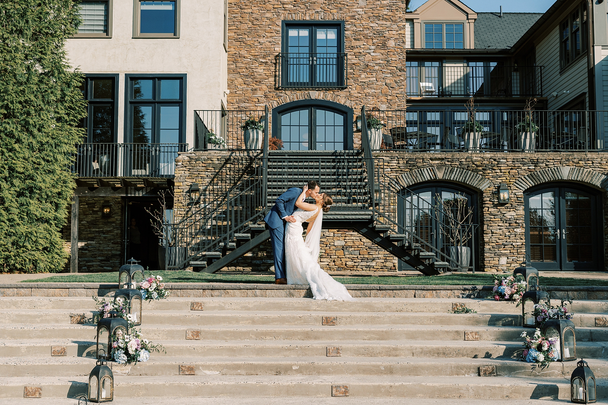 newlyweds kiss on staircase outside Lake House Inn