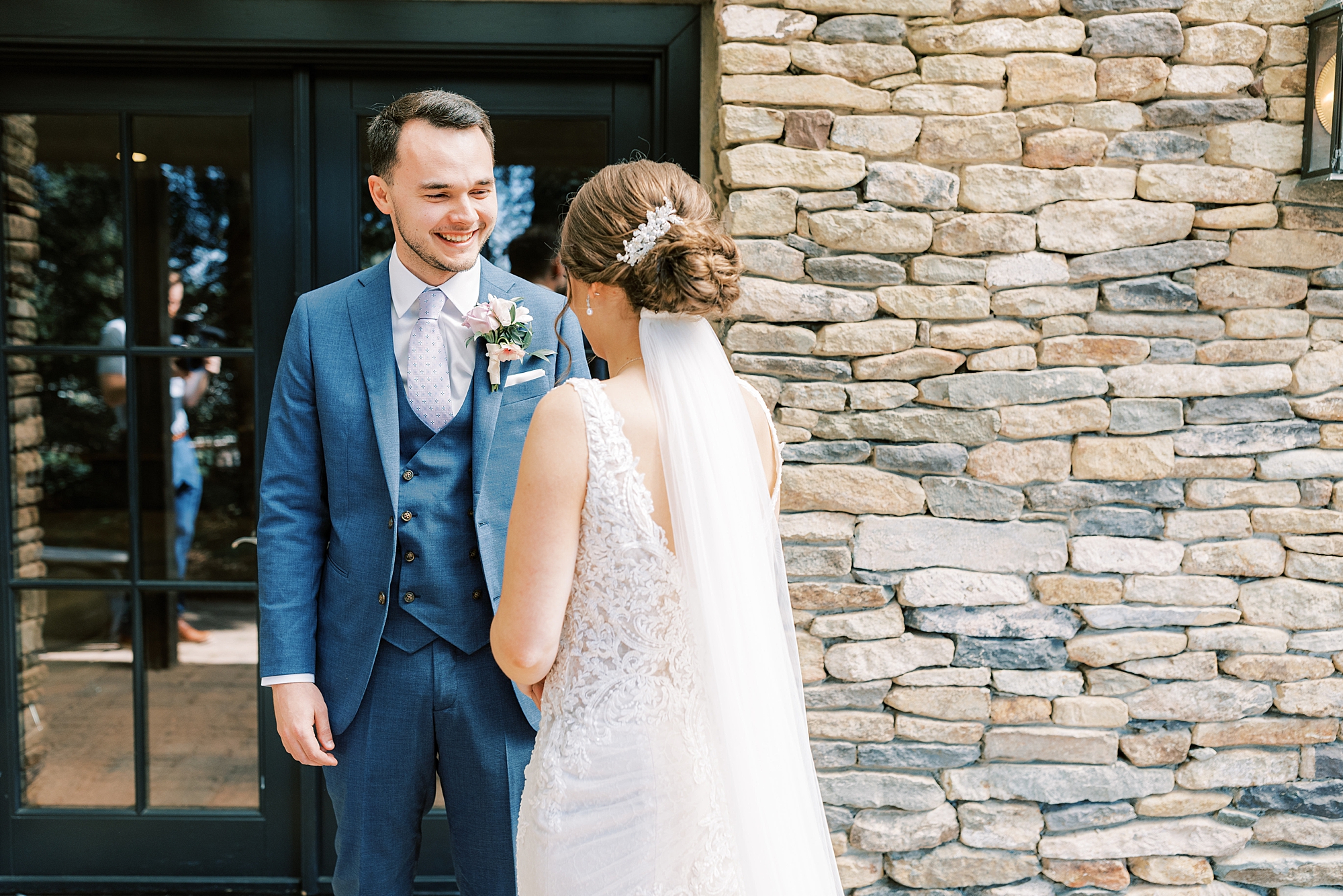 groom smiles turning to see bride during first look 