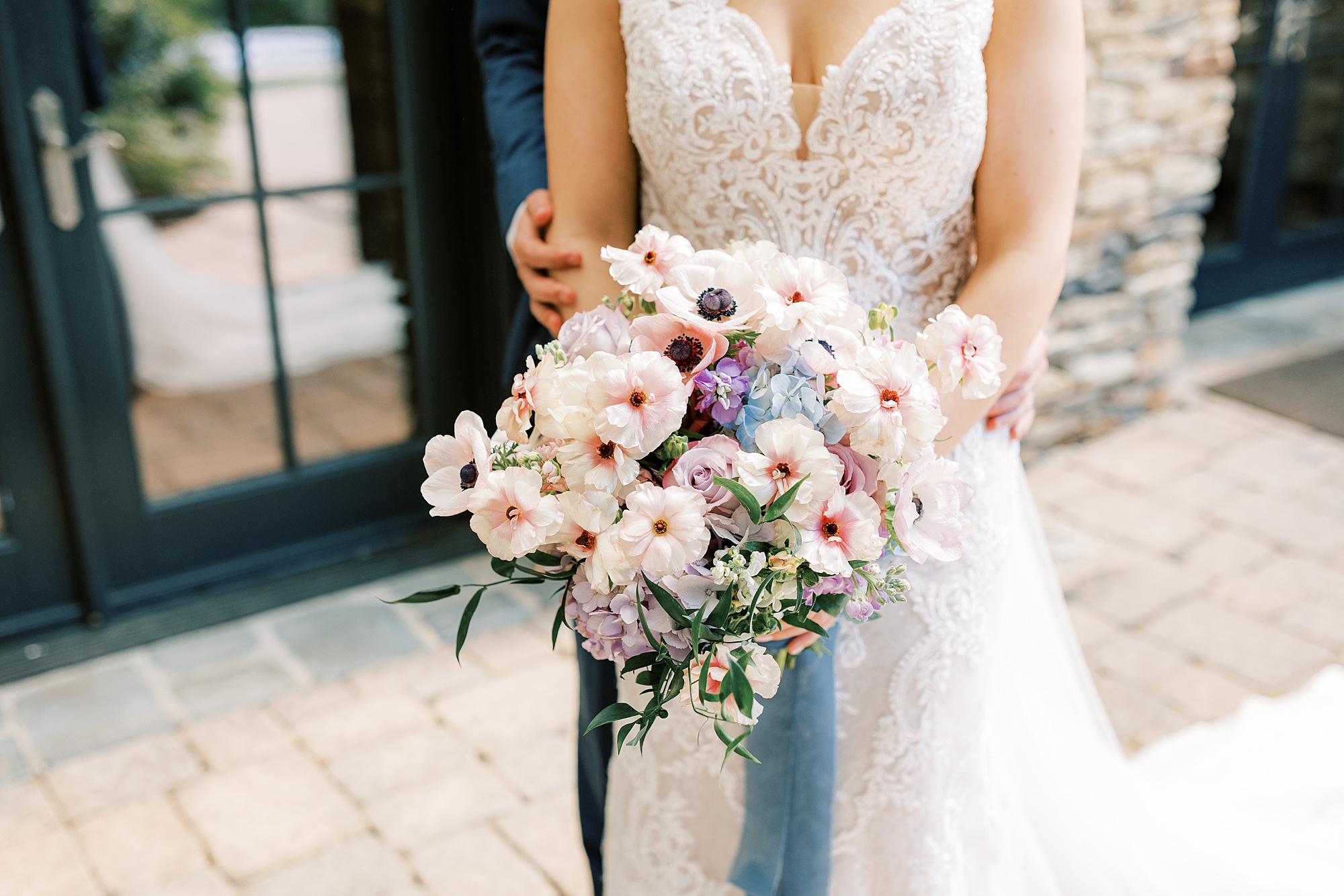 bride holds bouquet of pink flowers with long blue ribbon 