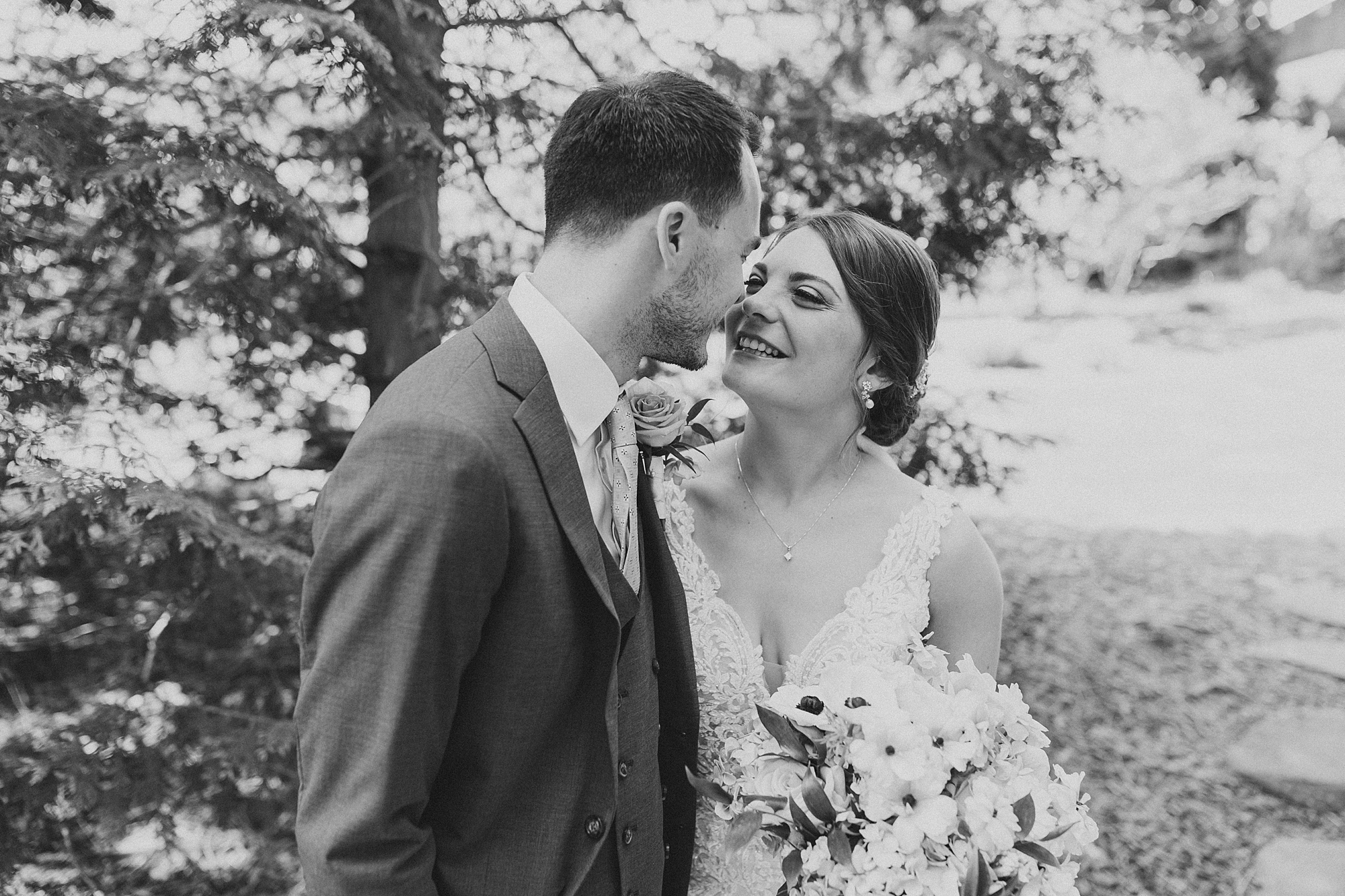 bride and groom lean together for kiss during PA wedding photos 