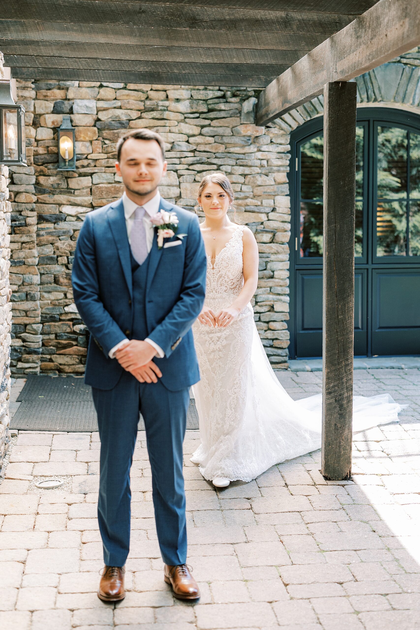 bride walks up behind groom for first look outside Lake House Inn