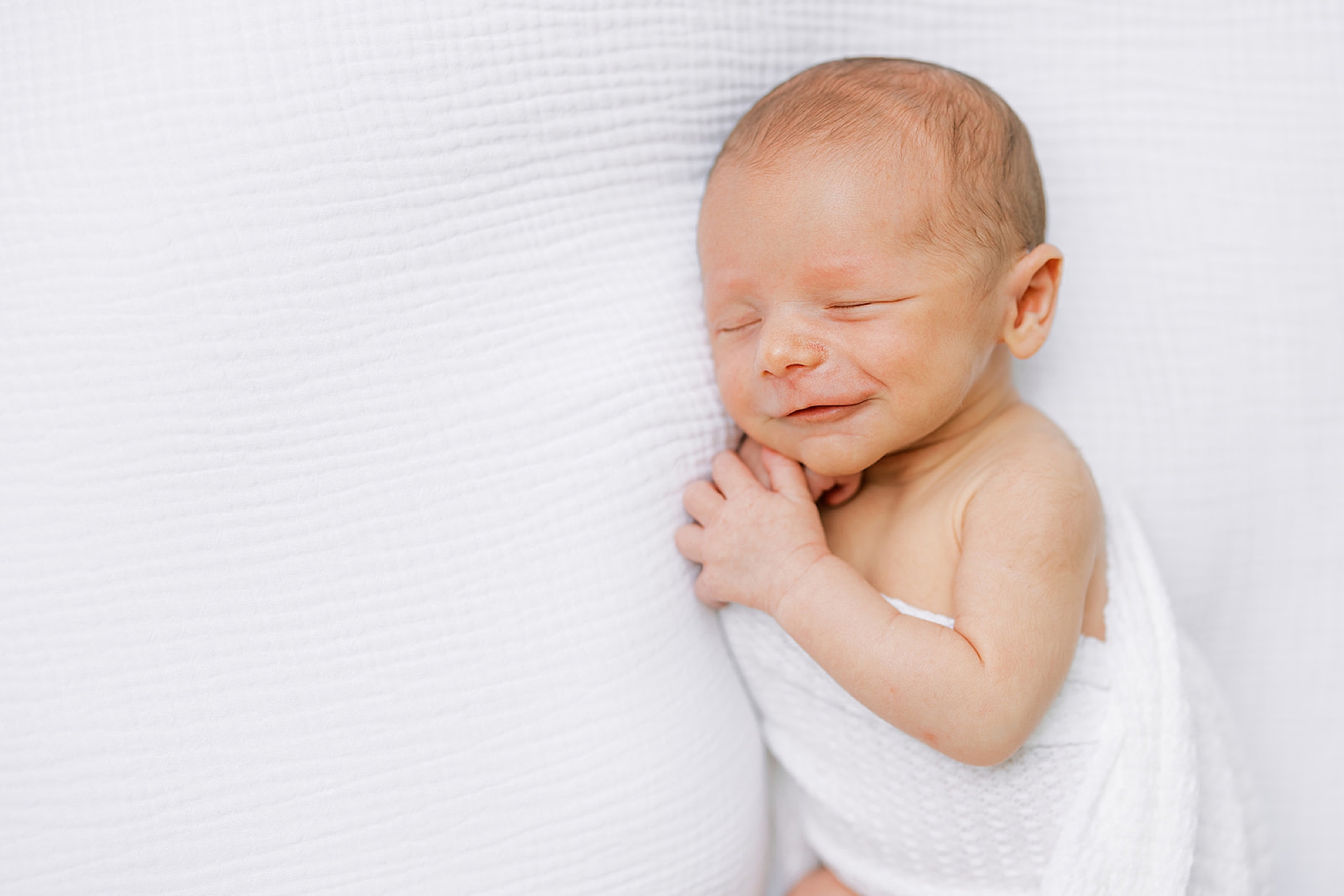 baby smiles in his sleep during studio newborn photos in Media PA