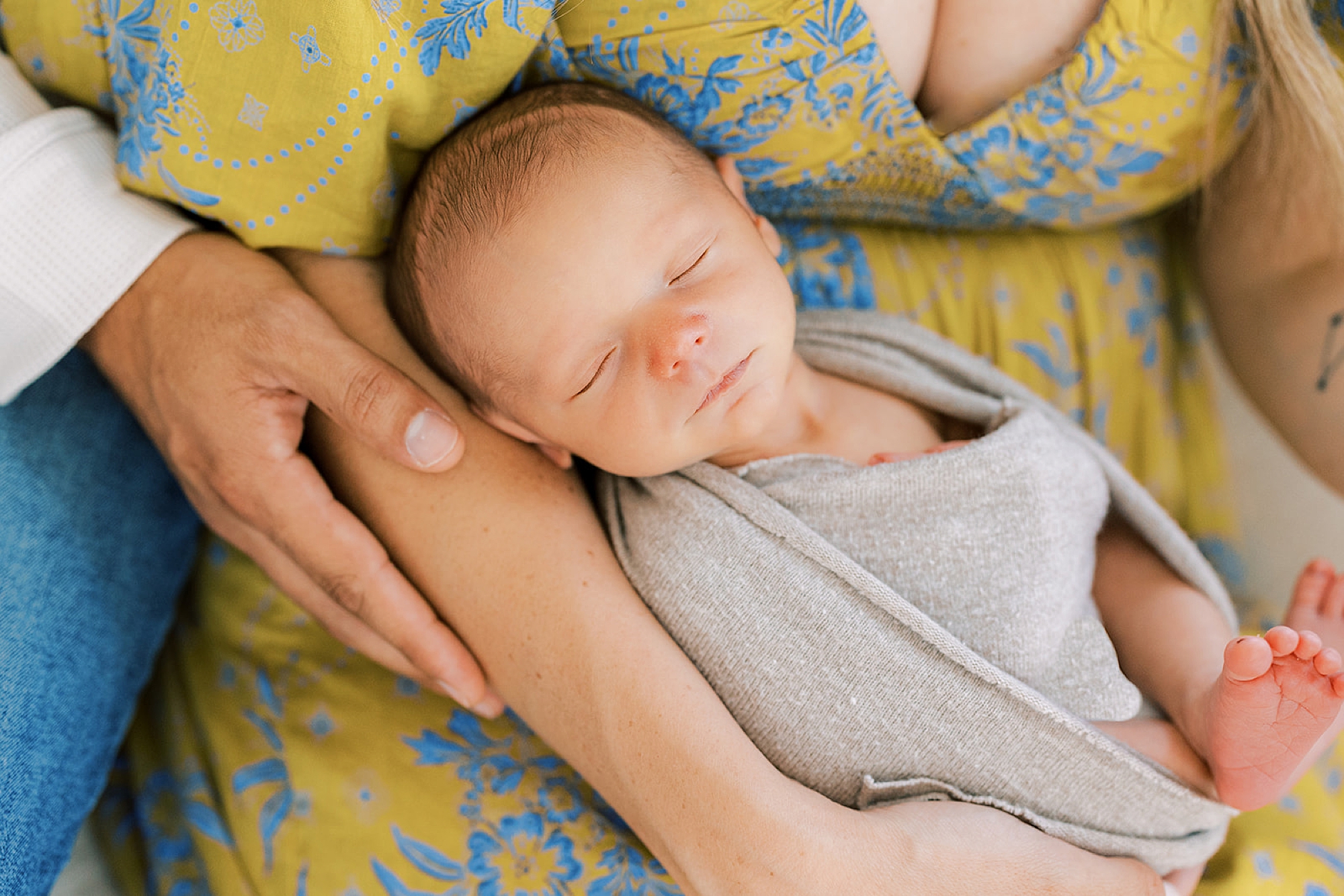 baby boy lays in mom's lap during newborn photos in Pennsylvania 